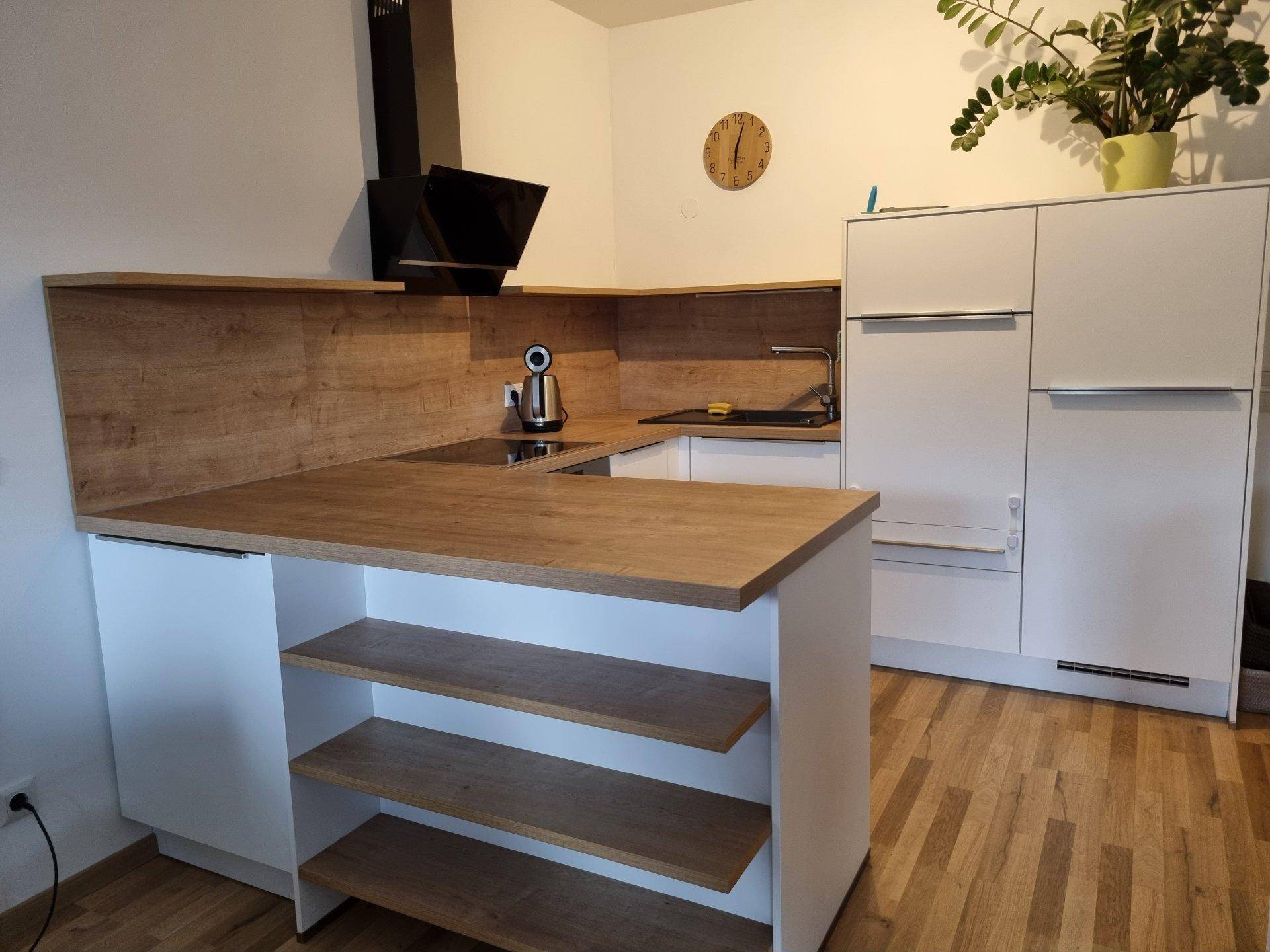 Moderne Küche mit weißen Schränken, Holzarbeitsplatten und einer praktischen Kücheninsel mit Ablageflächen.