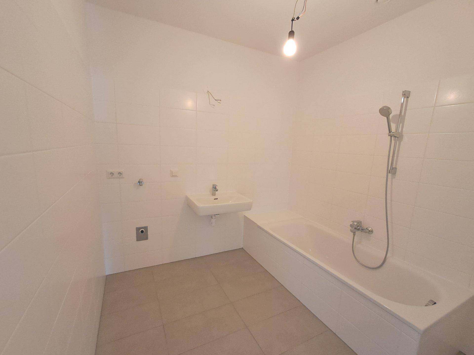 Unmöbliertes Badezimmer mit Badewanne und Fliesenboden, bietet Raum für individuelle Gestaltung.