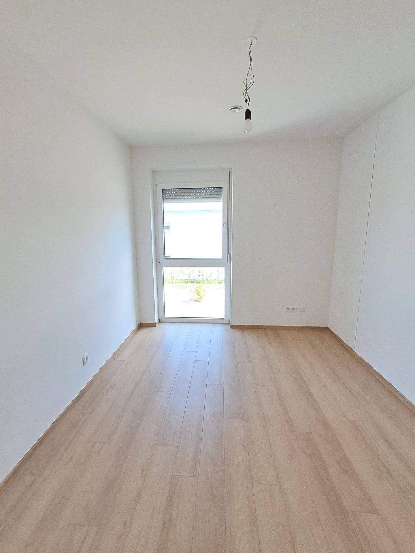 Unmöbliertes Zimmer mit Laminatboden und Fenster, vielseitig nutzbar als Schlaf- oder Arbeitszimmer.