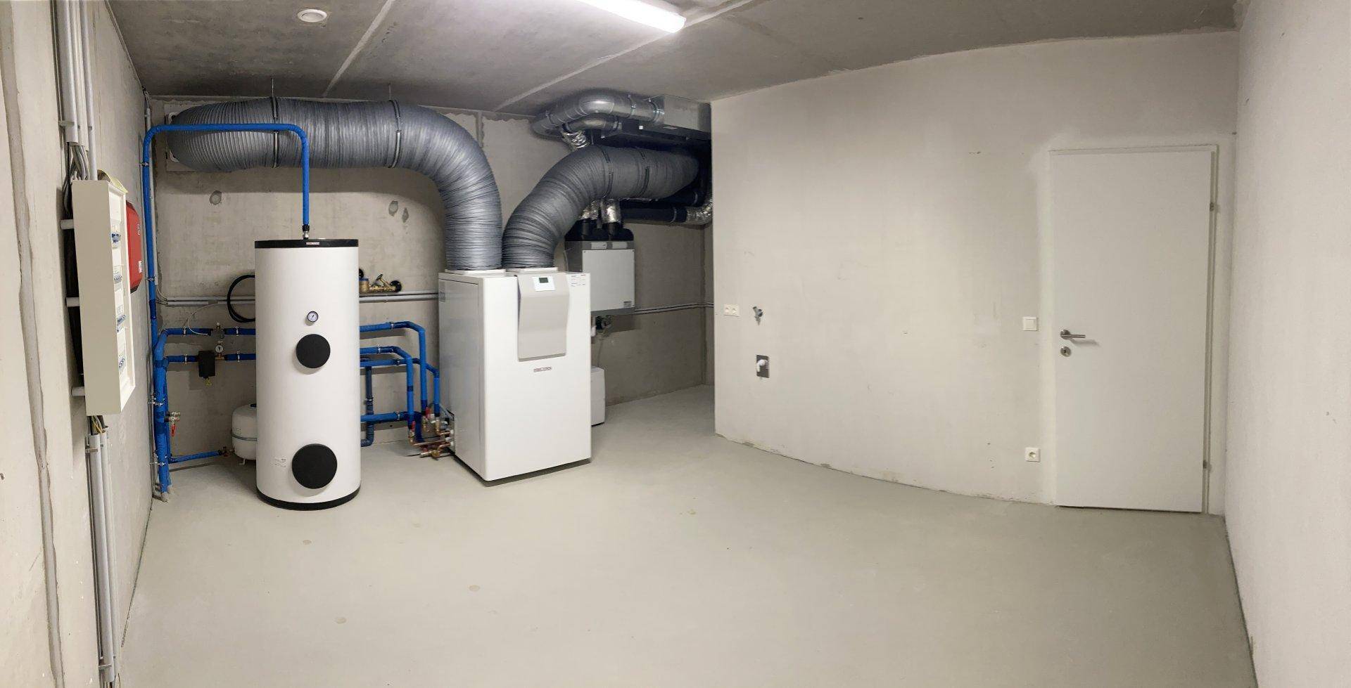 Technikraum im Keller mit Heizungsanlage und Warmwasserspeicher.