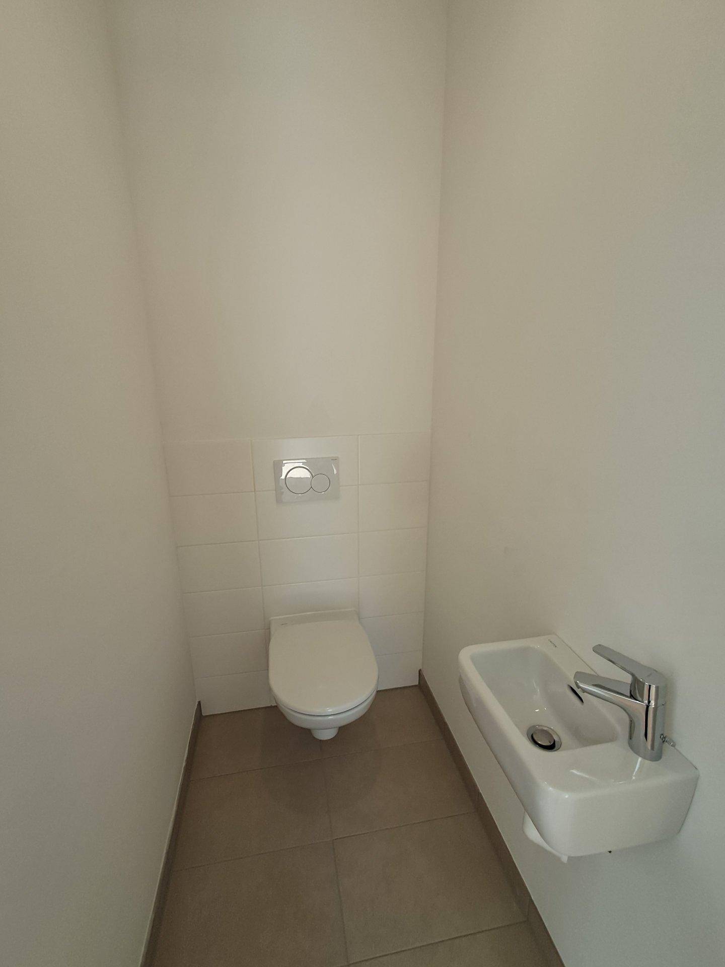 Modernes Gäste-WC mit wandhängendem WC und kleinem Waschbecken, praktisch und funktional.