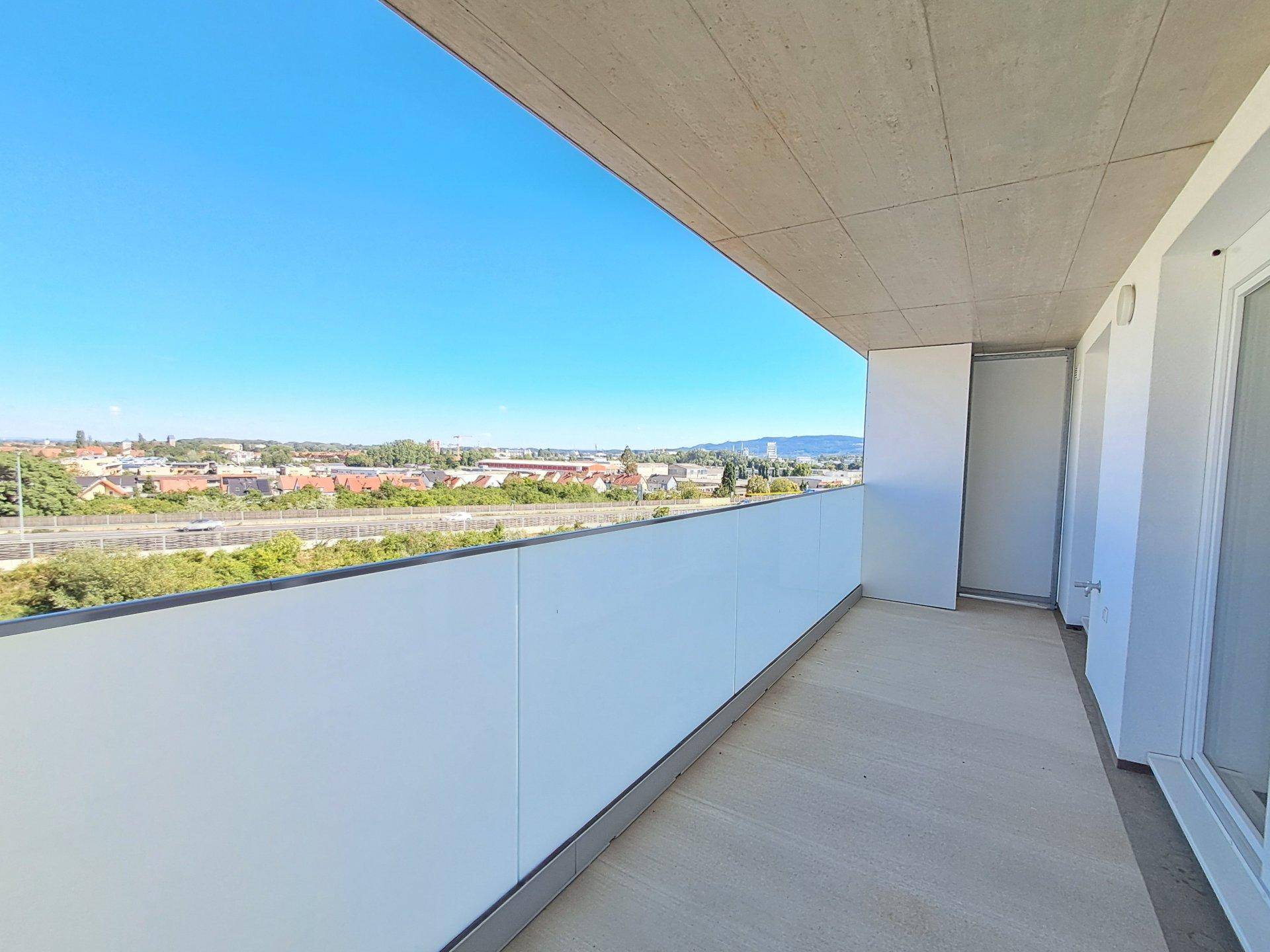 Geräumiger Balkon mit moderner Brüstung und weitem Blick über die Stadtlandschaft.