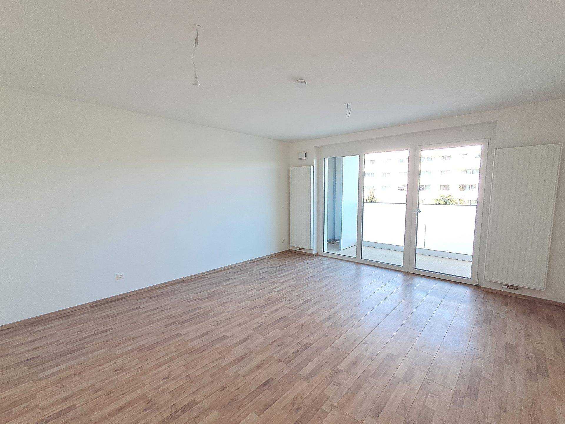 Heller Wohnraum mit großen Fenstern und Blick auf die umliegenden Gebäude, ideal für Entspannung.
