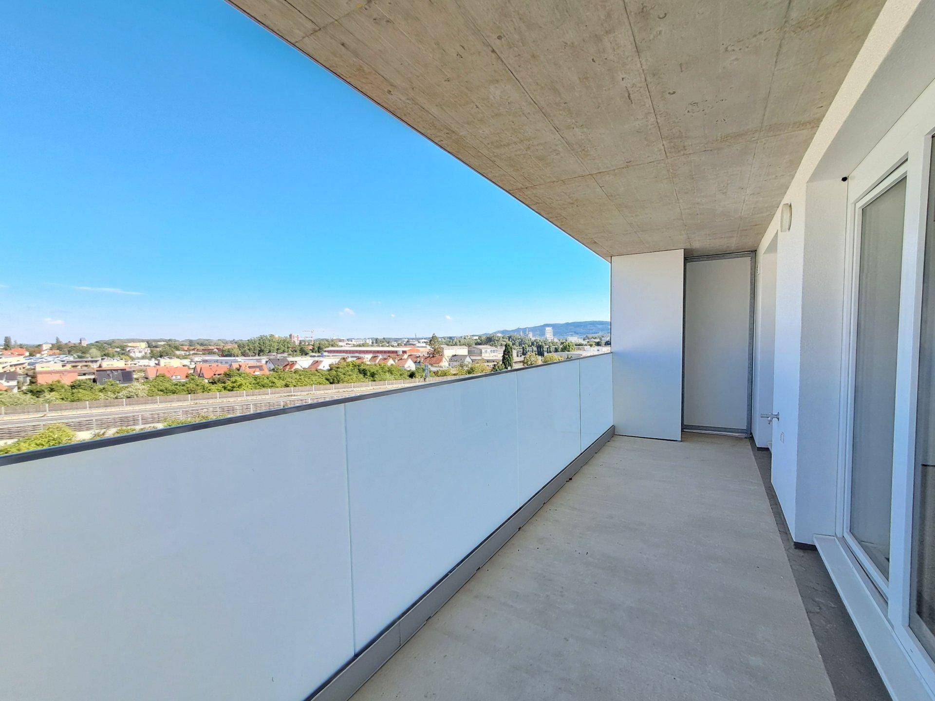 Geräumiger Balkon mit weitem Blick über die Stadt und die umliegende Landschaft.