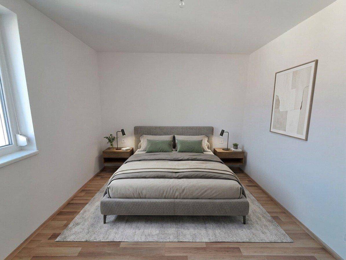 Modernes Schlafzimmer mit grauem Bett, Nachttischen und einem Fenster, hell und schlicht eingerichtet.