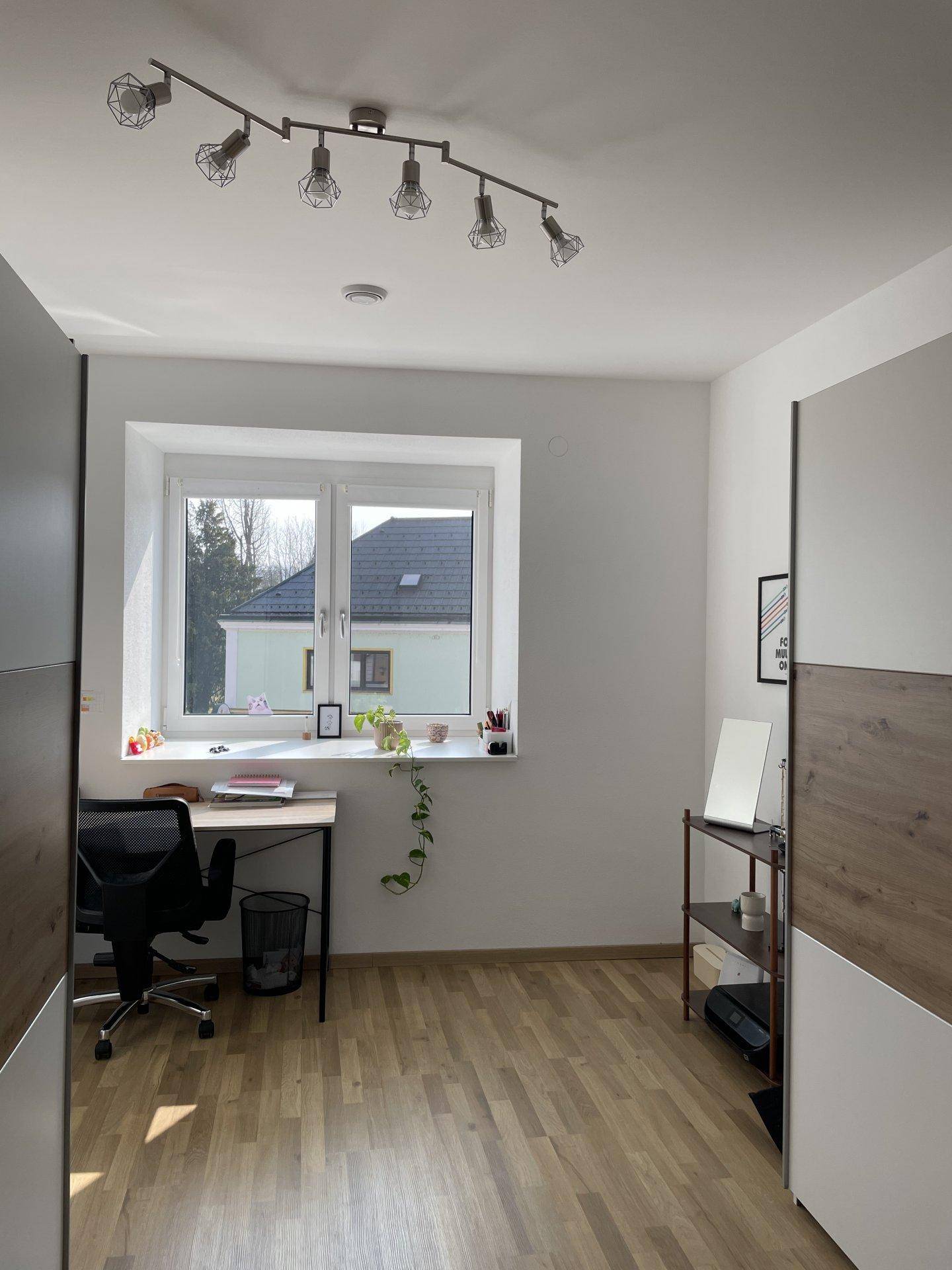 Helles Arbeitszimmer mit Schreibtisch, Bürostuhl und großem Fenster für viel Tageslicht.