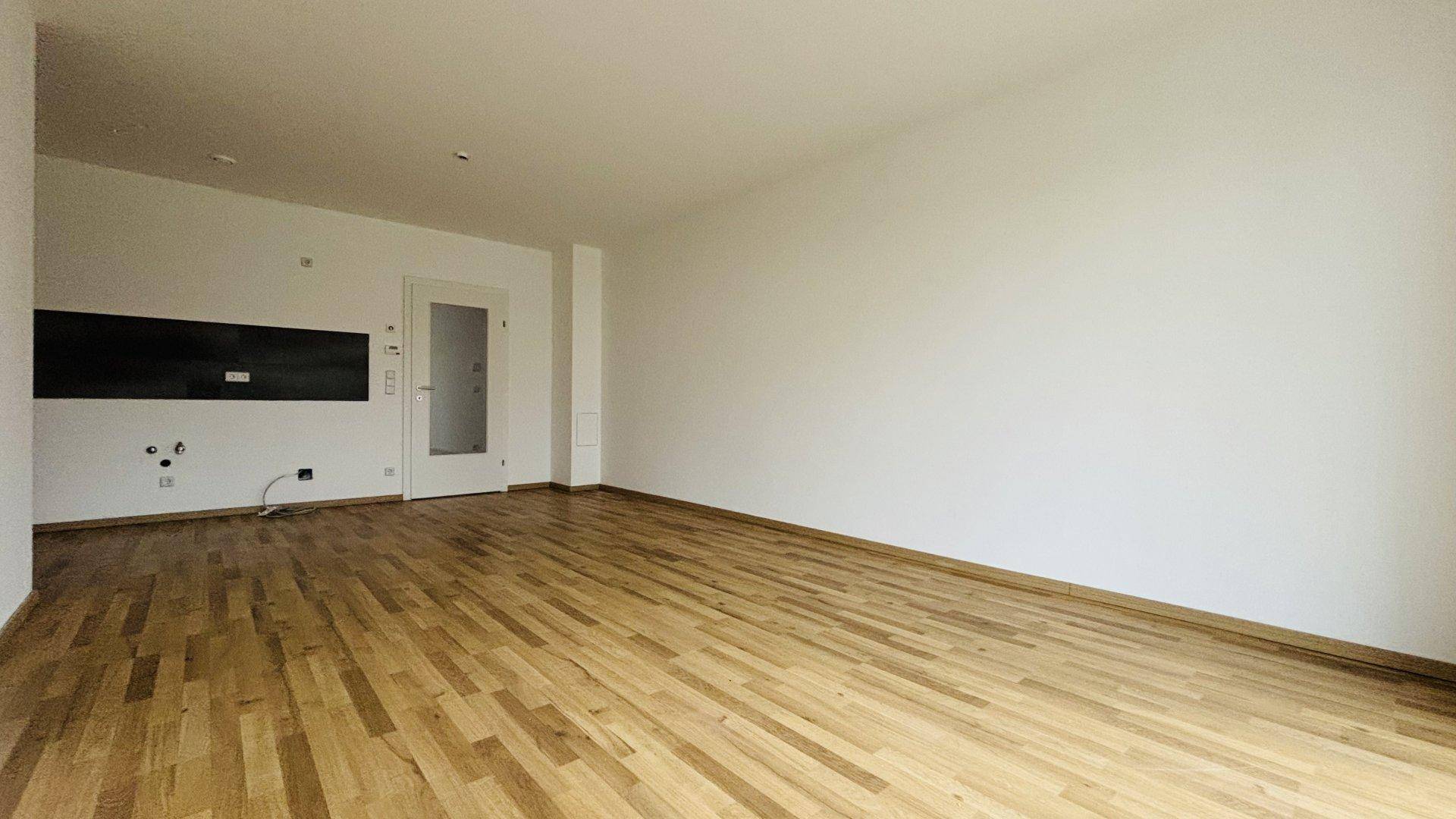 Weitläufiges Wohnzimmer mit Eichenparkett und viel Potenzial für individuelle Gestaltung.