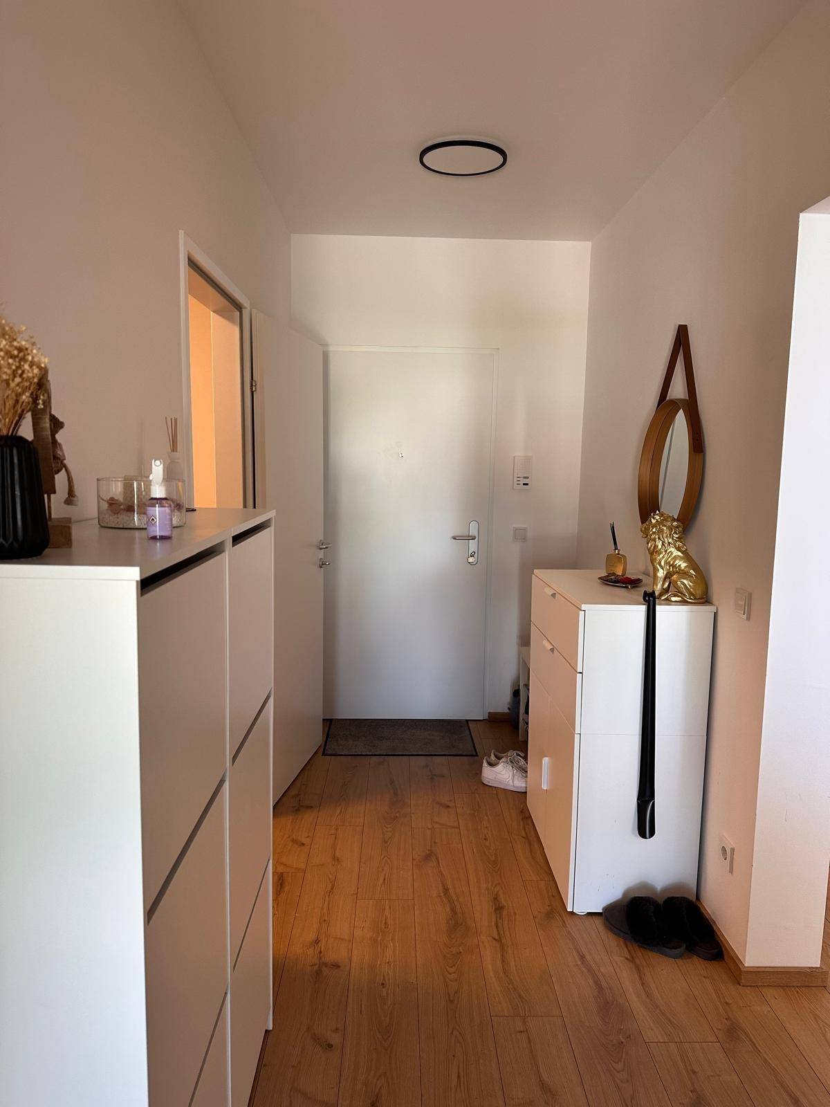 Heller Eingangsbereich mit Laminatboden und praktischen Schuhschränken für Ordnung.