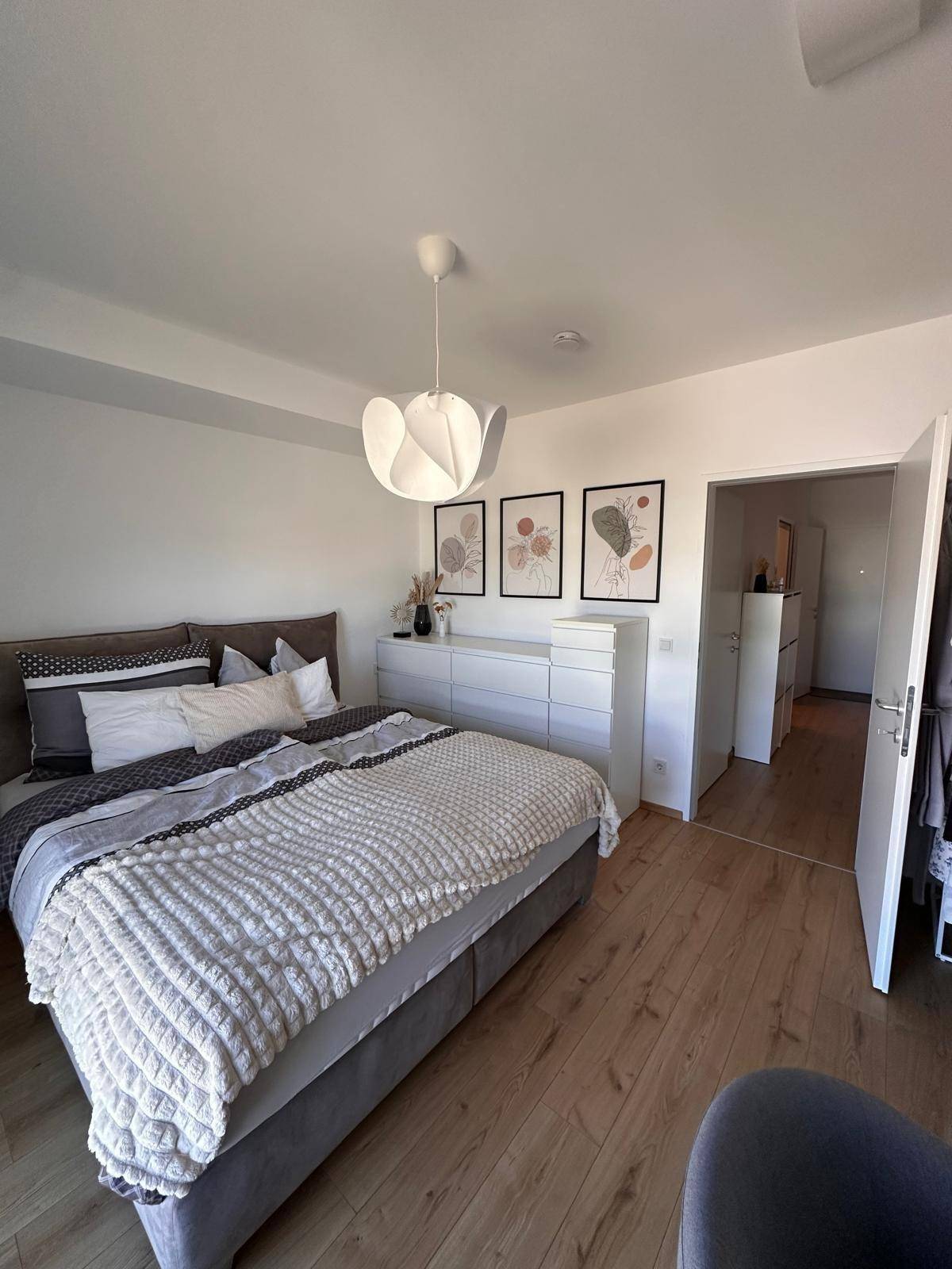 Helles Schlafzimmer mit modernem Doppelbett und Zugang zum Flur, stilvoll eingerichtet.