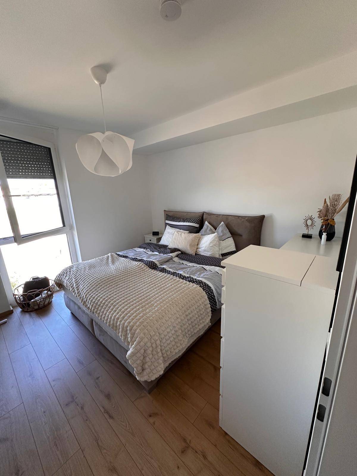 Gemütliches Schlafzimmer mit Doppelbett, Nachttischen und großem Fenster für viel Licht.