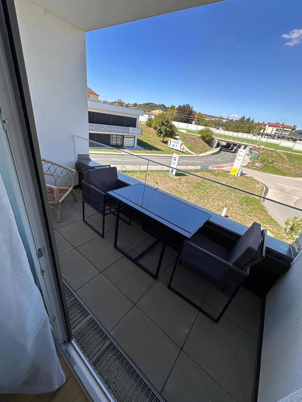 Gemütlicher Balkon mit Sitzgelegenheiten und weitem Blick auf die grüne Umgebung.