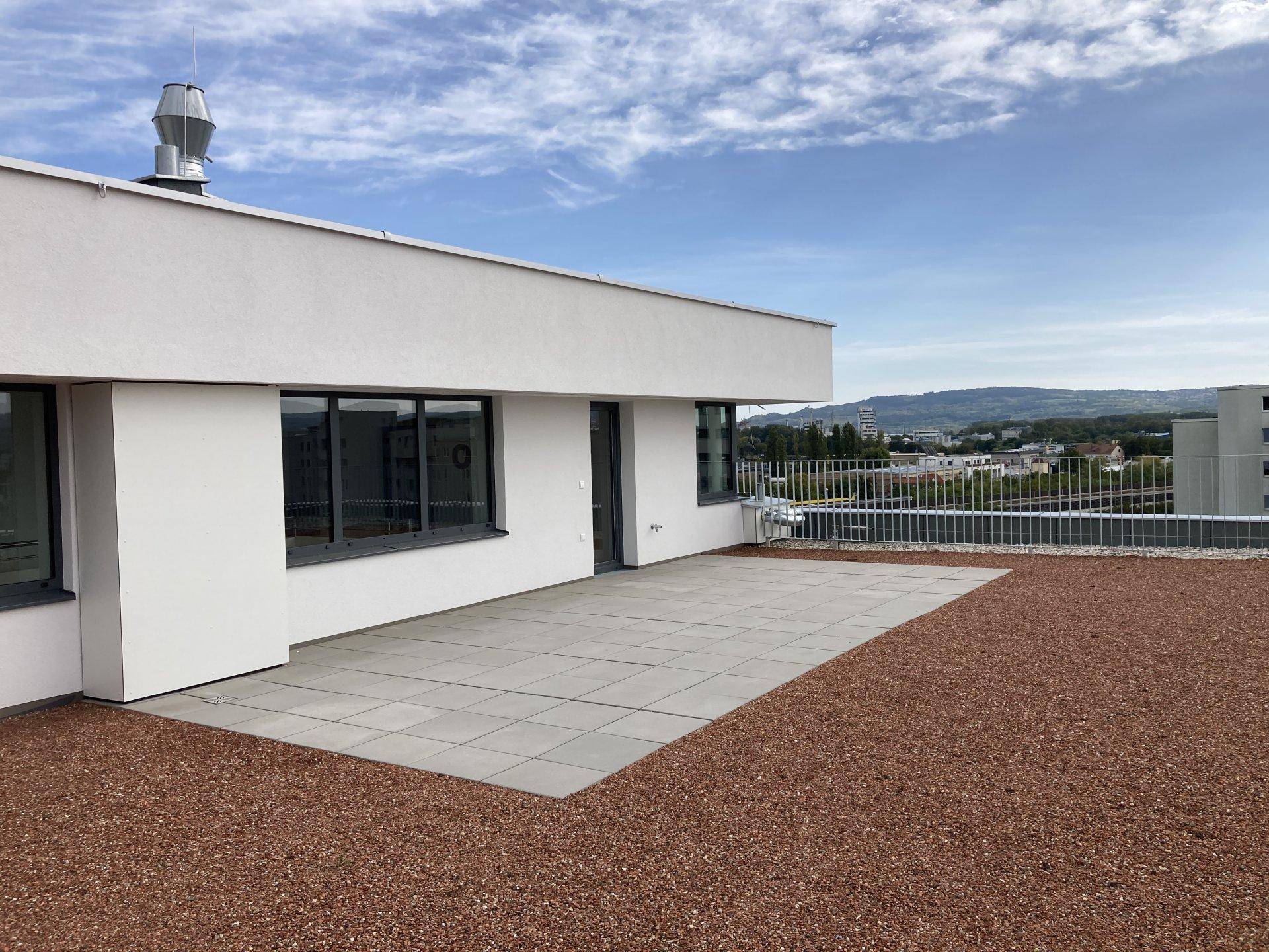 Dachterrasse mit Fliesen und extensiver Begrünung, bietet Platz für Outdoor-Aktivitäten.