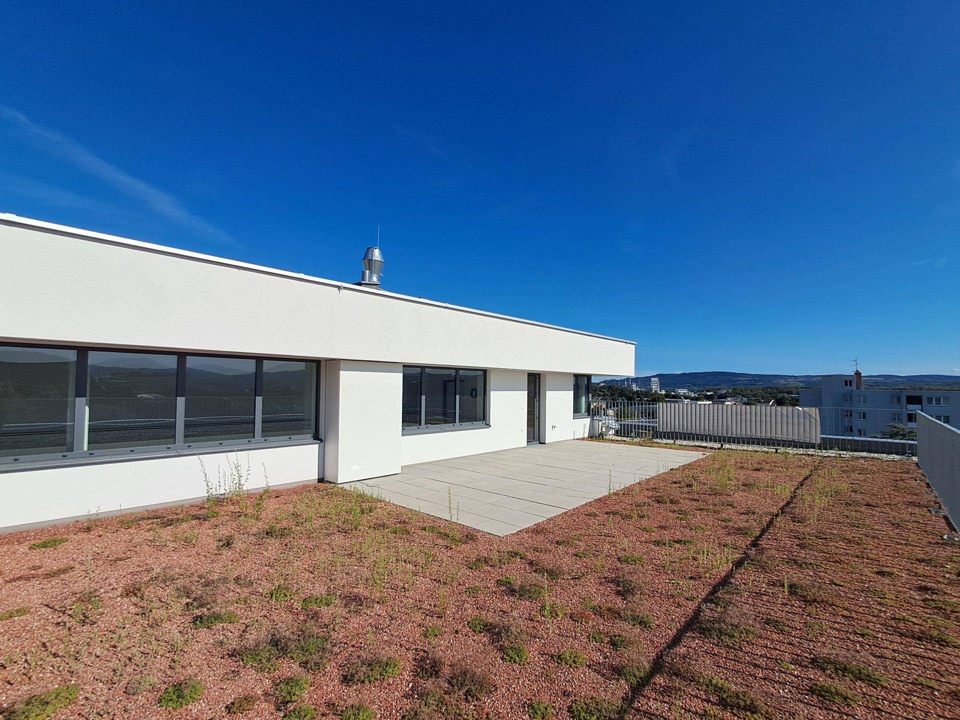 Weitläufige Dachterrasse mit Fliesen und extensiver Begrünung, bietet einen schönen Ausblick.