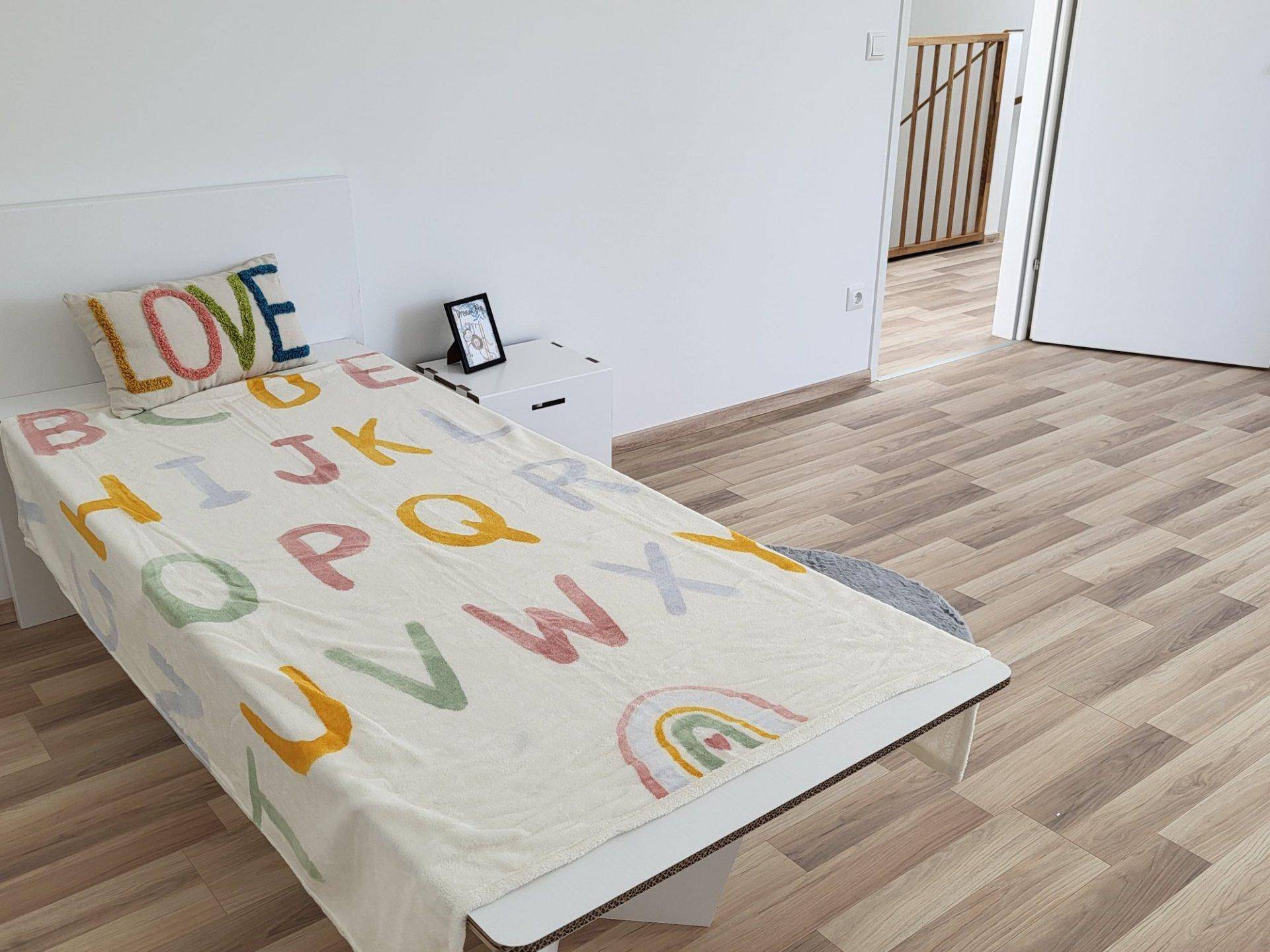 Kinderzimmer mit Laminatboden und bunter Decke, ideal für junge Familien.