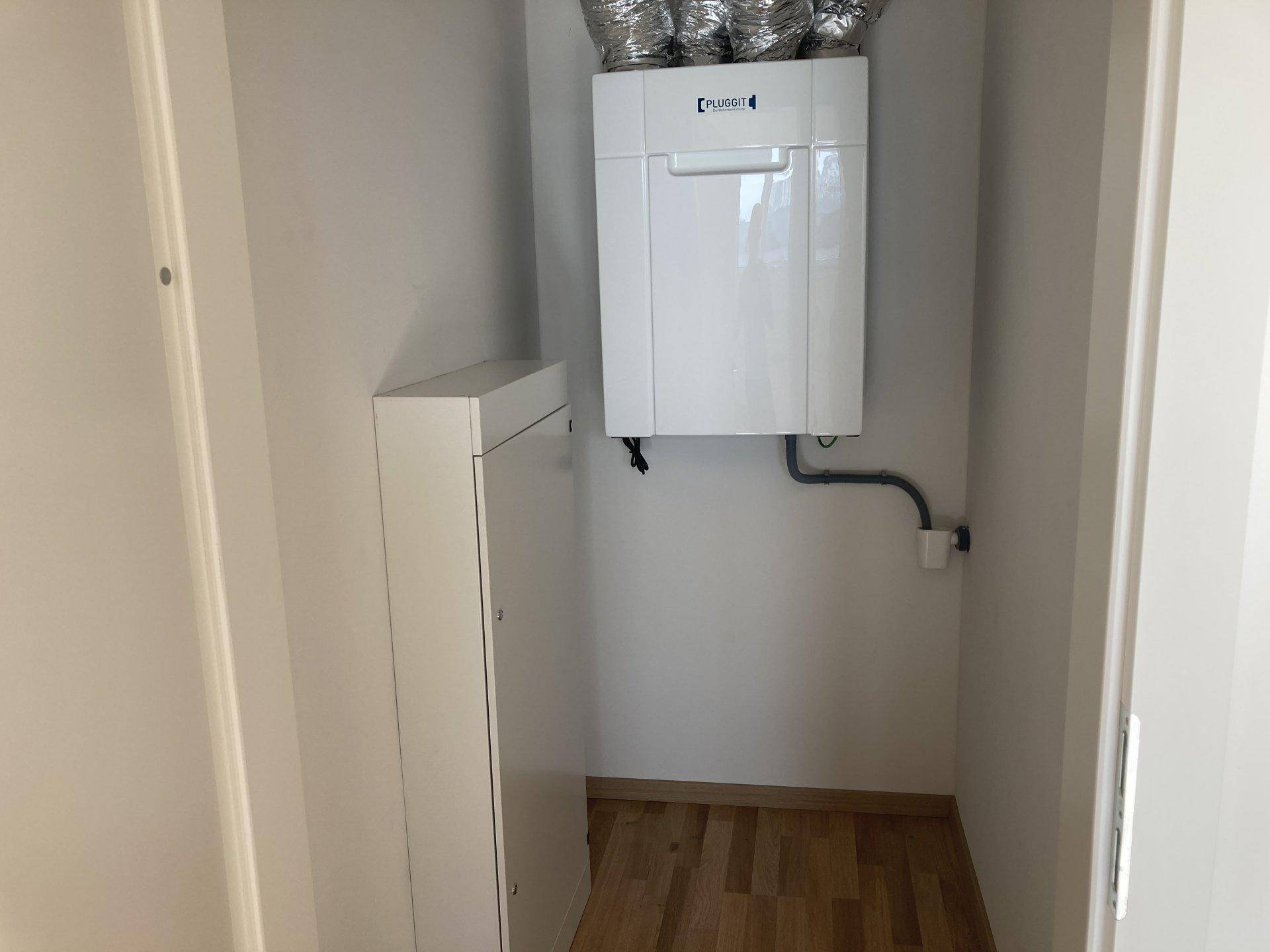 Kleiner Hauswirtschaftsraum mit Lüftungsanlage und Stauraum.