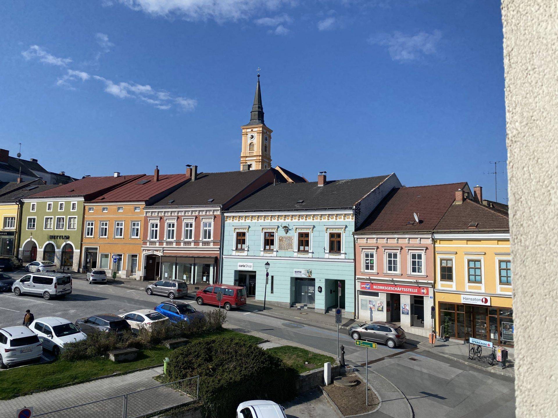 Ansicht einer charmanten Stadtstraße mit bunten Häusern und Kirchturm.