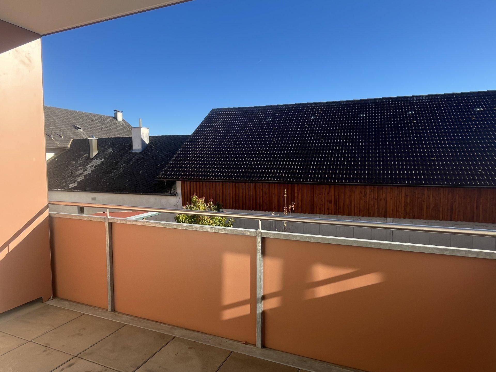 Sonniger Balkon mit braunen Sichtschutzwänden und Fliesenboden, ideal für entspannte Stunden im Freien.