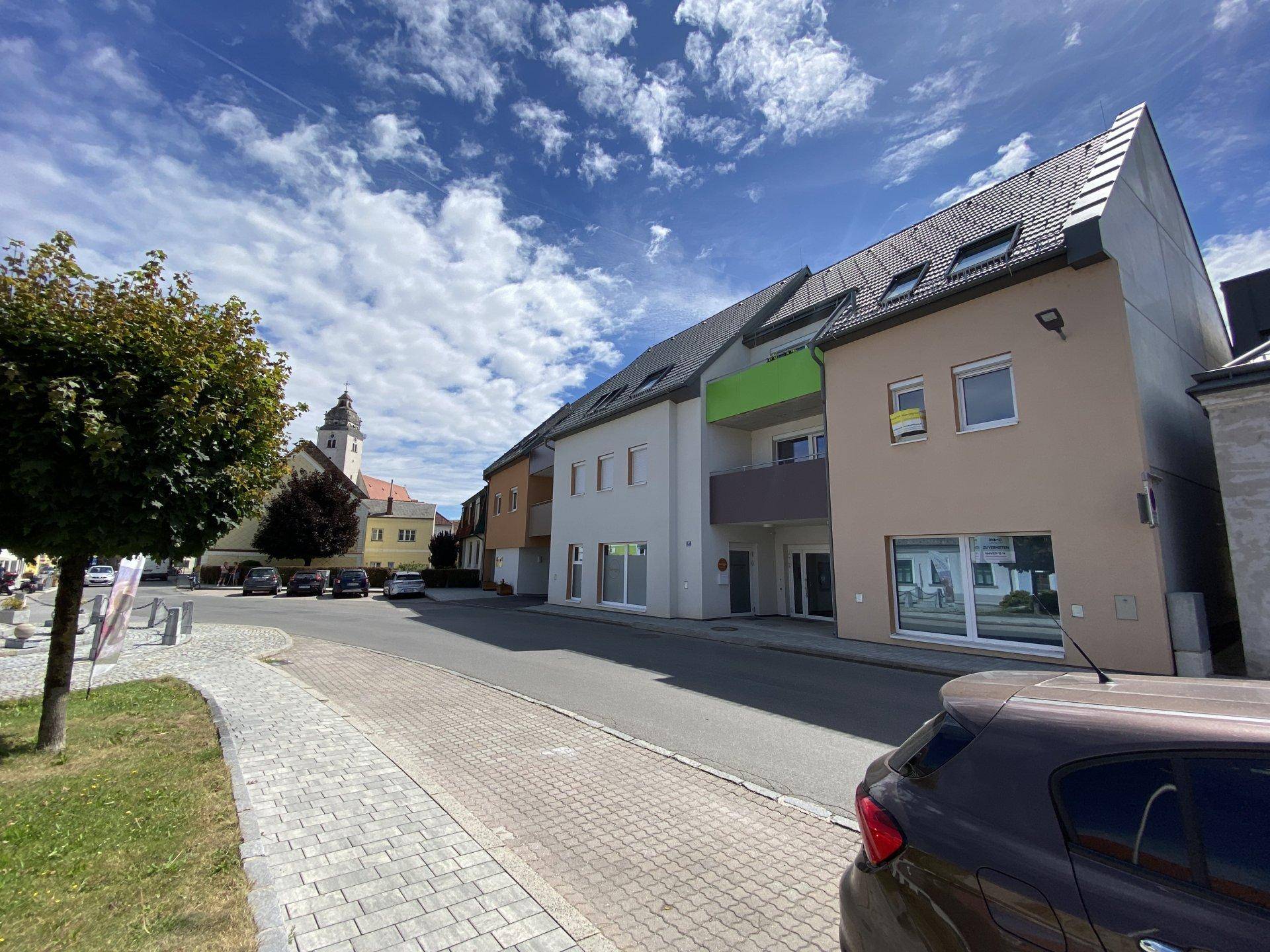 Seitenansicht der Wohngebäude mit schrägen Dächern und Fenstern entlang der Straße.