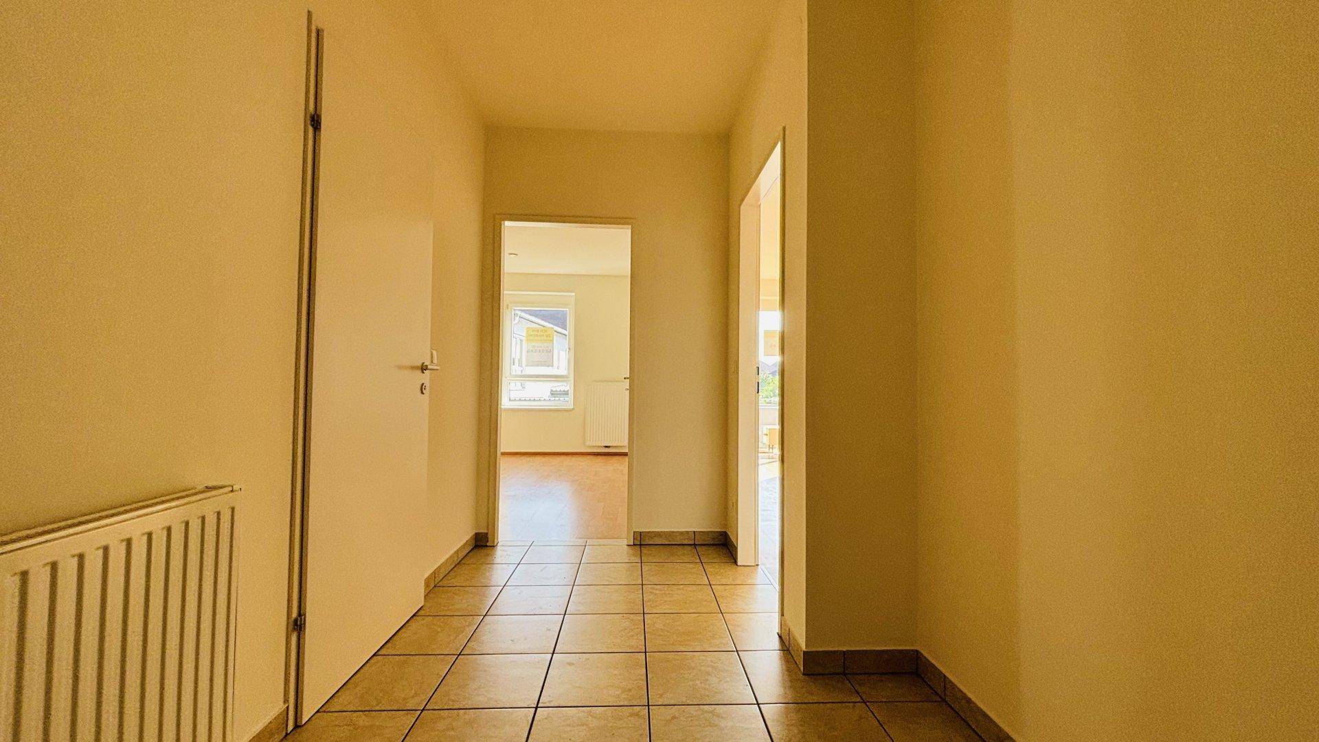 Heller Flur mit Fliesenboden und Türen zu den angrenzenden Zimmern der Wohnung.