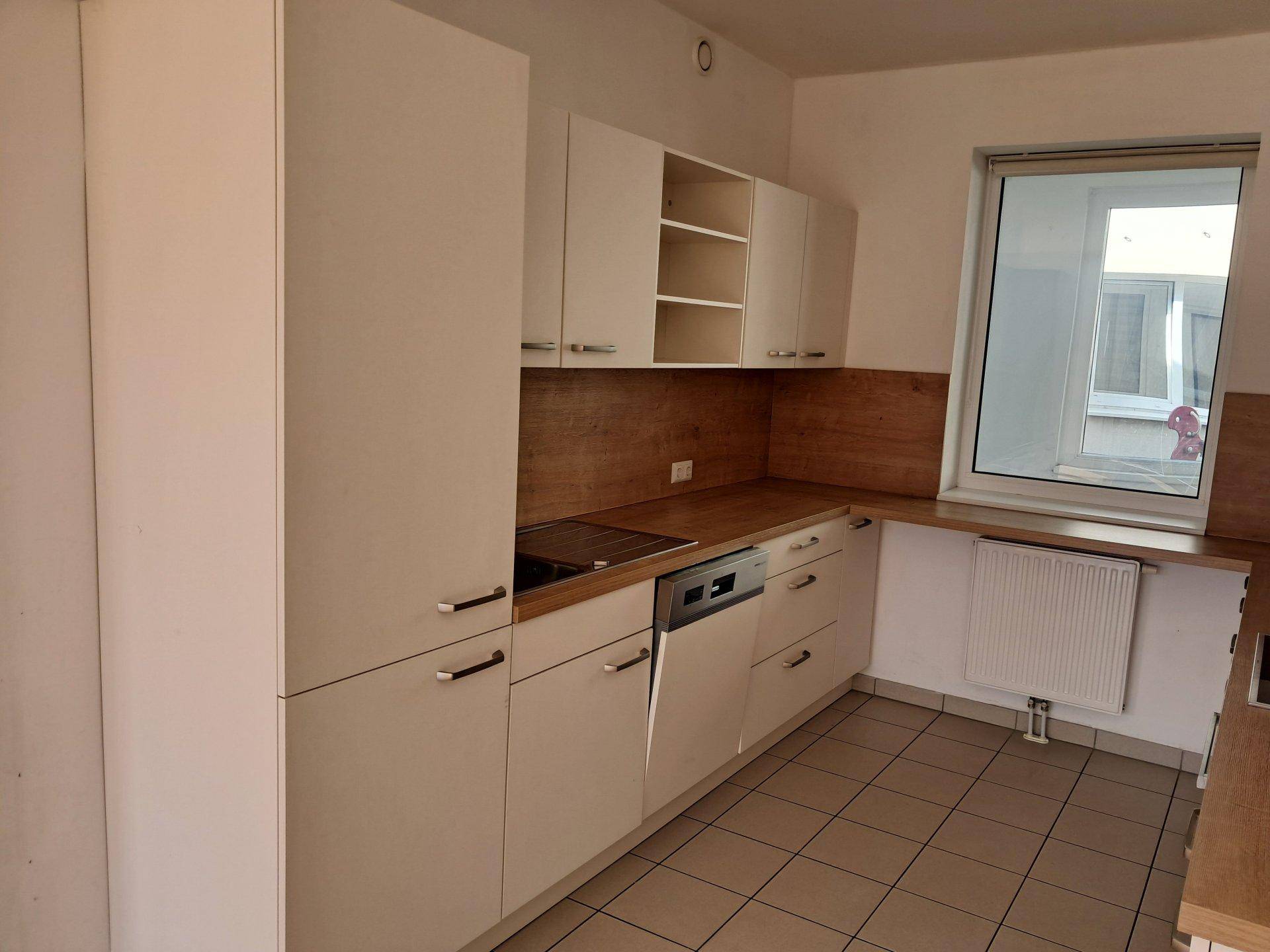 Funktionale Küche mit weißen Schränken, Holzoptik-Arbeitsplatten und Geschirrspüler.