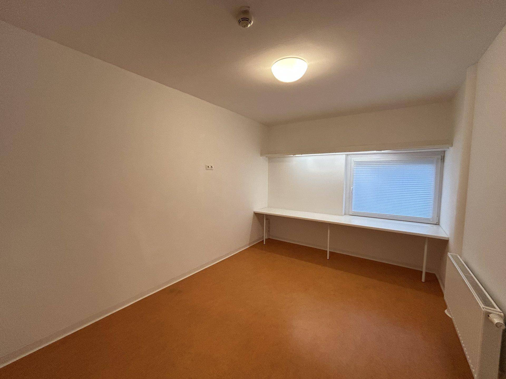 Helles, unmöbliertes Zimmer mit Fenster und Vinylboden, ideal als Schlaf- oder Arbeitszimmer.