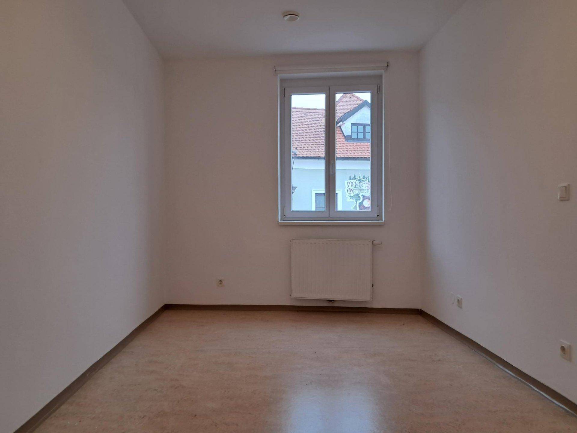 Leerer Raum mit einem großen Fenster, das viel Tageslicht hereinlässt.