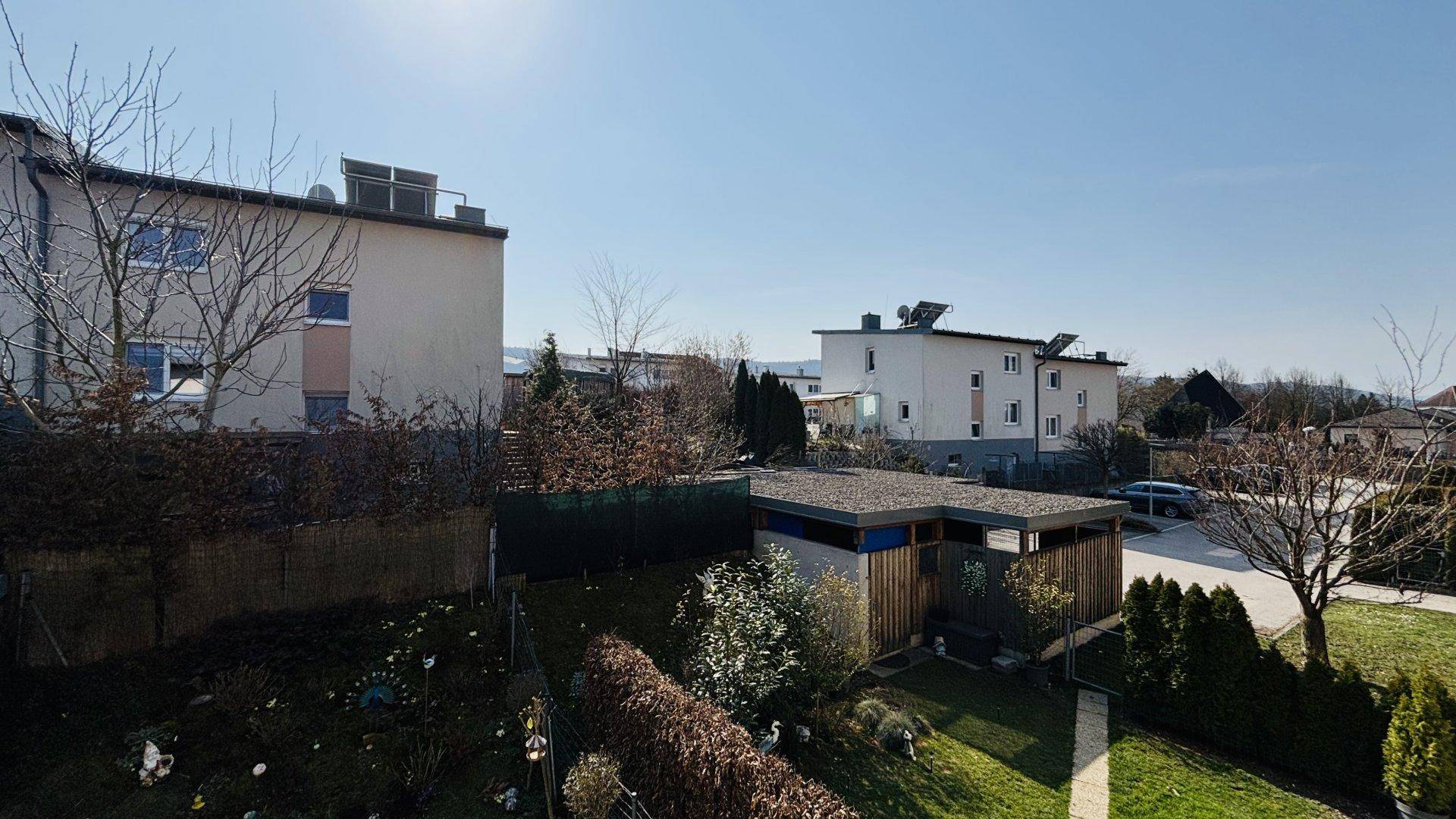Weitläufiger Blick über die Nachbarschaft mit Wohnhäusern, Gärten und viel Grün.
