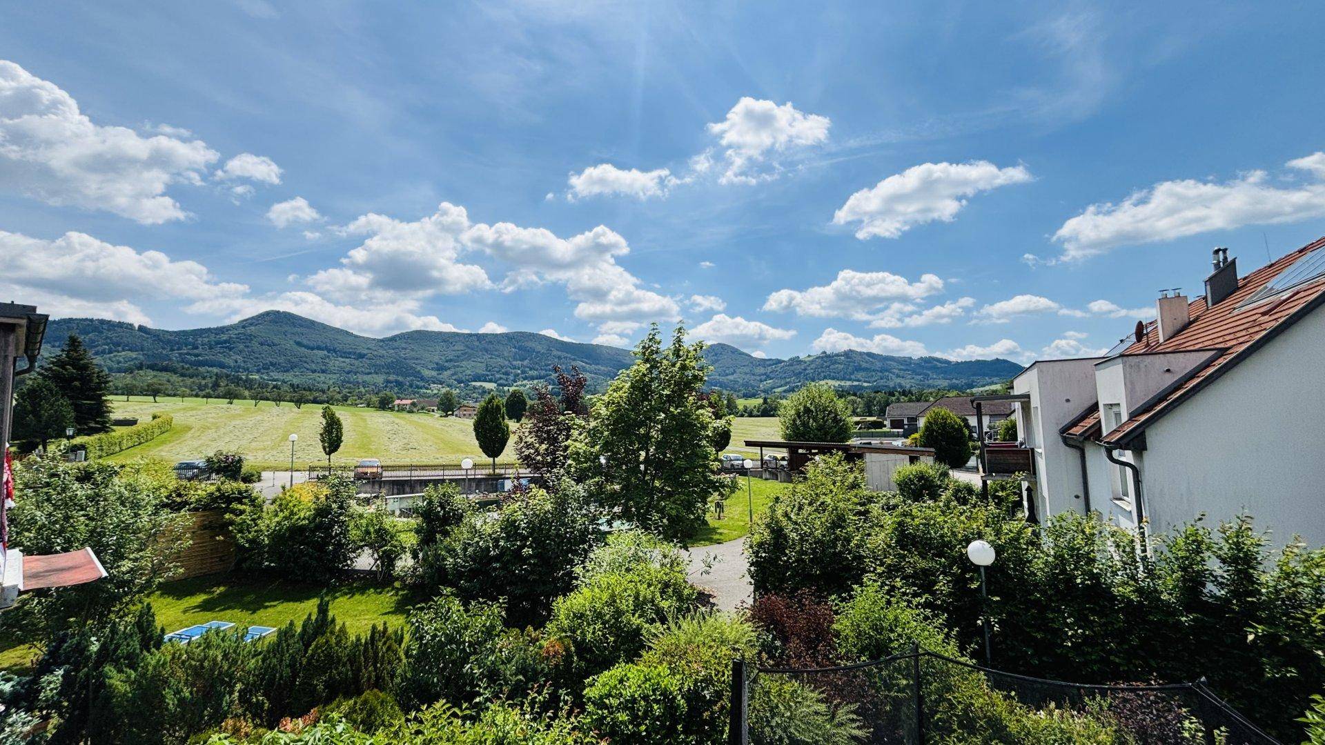 Panoramablick von der Immobilie auf die weite grüne Landschaft und die umliegenden Berge.
