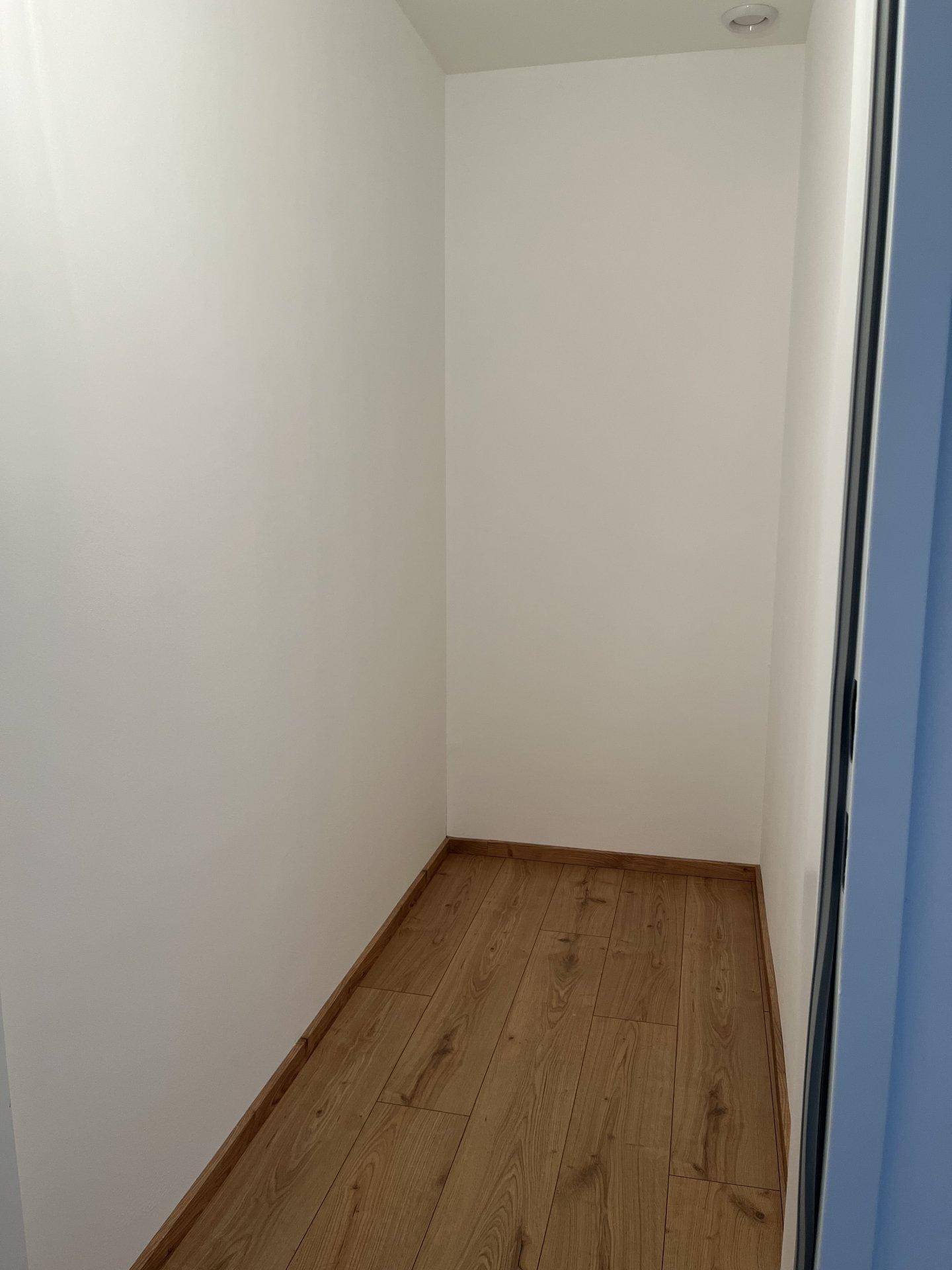 Kleiner, heller Abstellraum mit Laminatboden und weißen Wänden, ideal für zusätzlichen Stauraum.