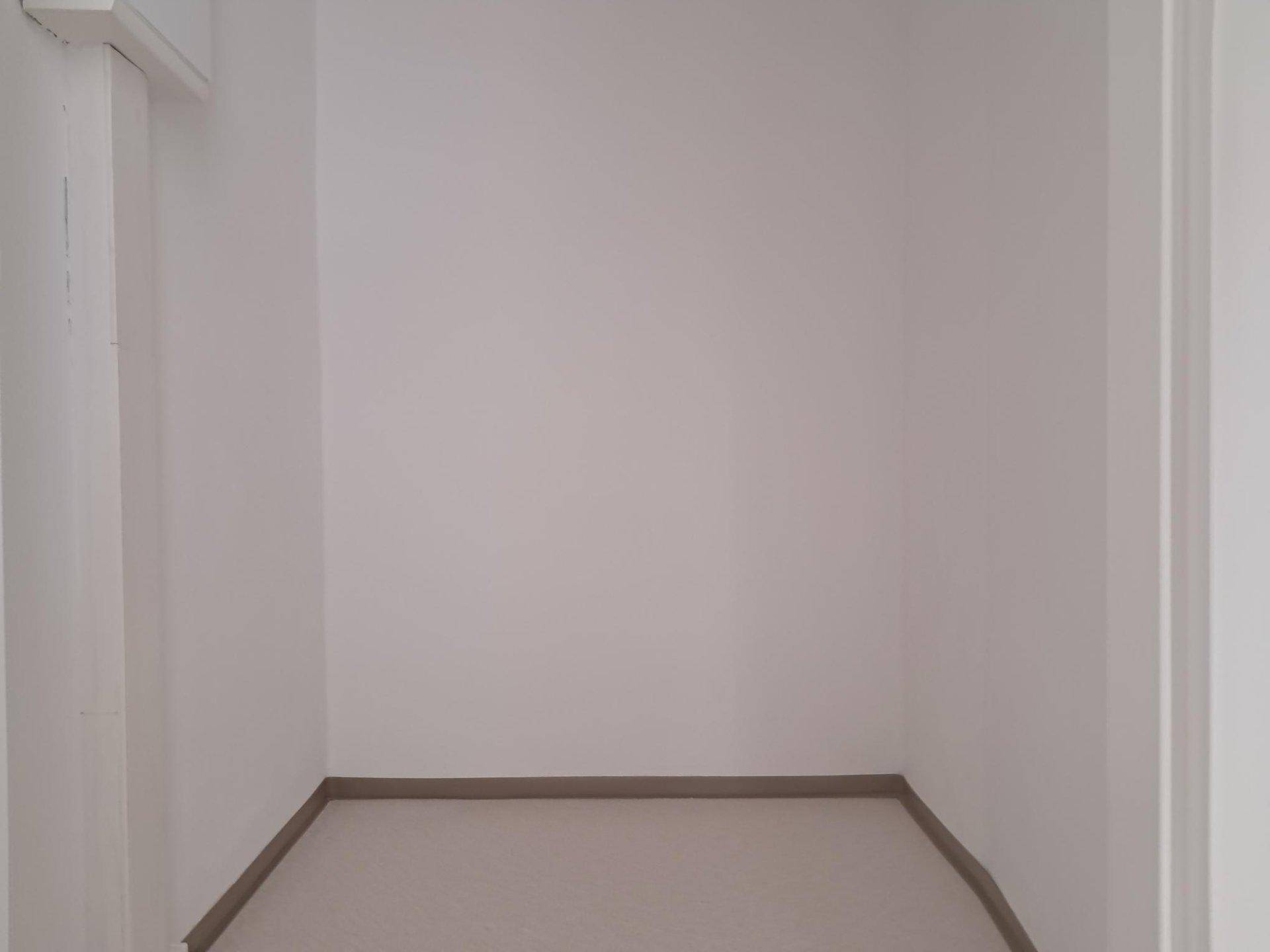 Kleiner, leerer Abstellraum mit weißen Wänden und hellem Boden für zusätzlichen Stauraum.