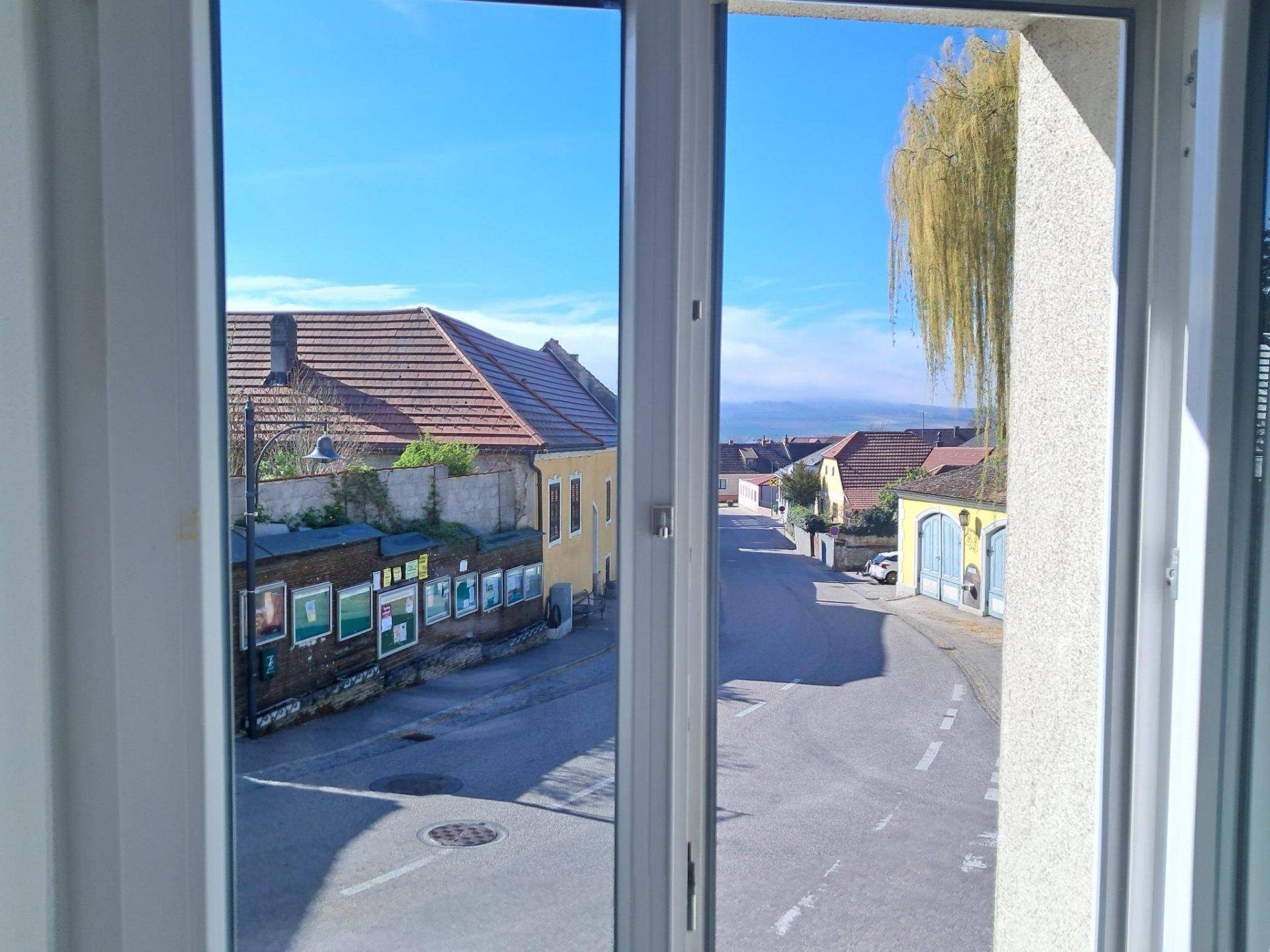 Ausblick aus dem Fenster auf eine ruhige Straße und die umliegenden Häuser der Nachbarschaft.