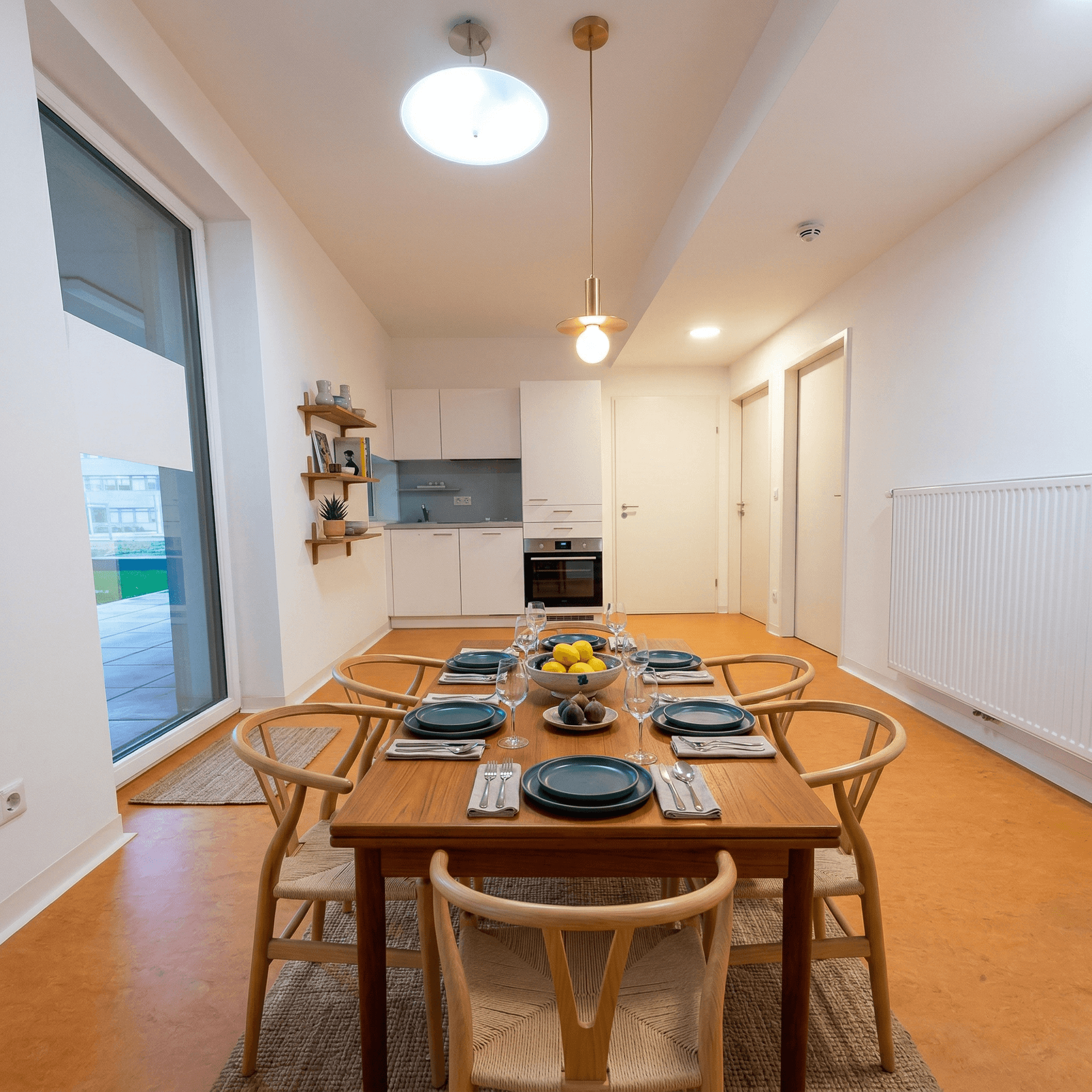 Heller Essbereich mit Holztisch und Stühlen, angrenzend an eine moderne Küchenzeile.