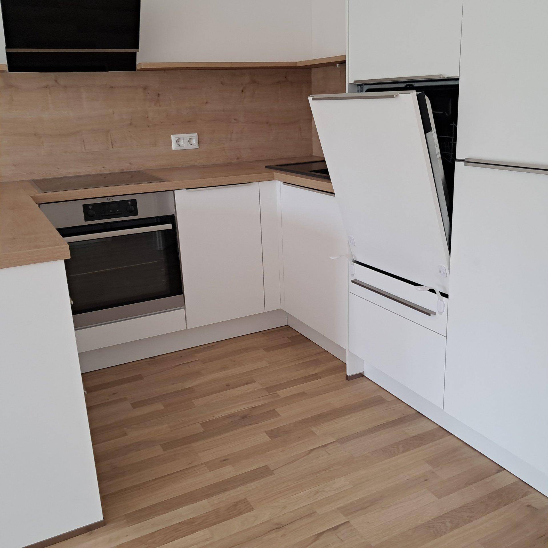 Moderne Küche mit integriertem Geschirrspüler, Backofen und Holzoptik-Arbeitsplatten.