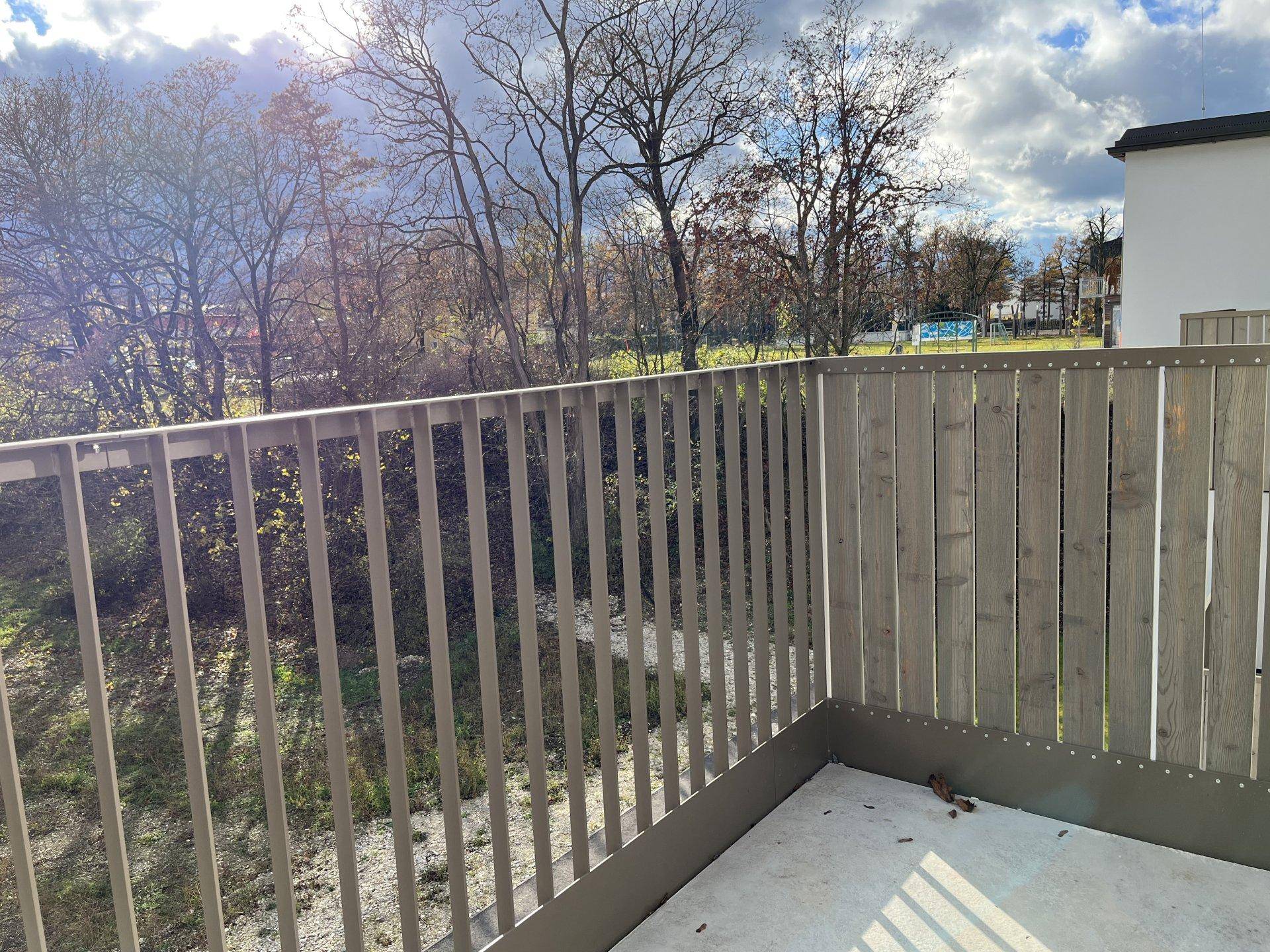Balkon mit Metallgeländer und weitem Blick ins Grüne, ideal zum Entspannen.
