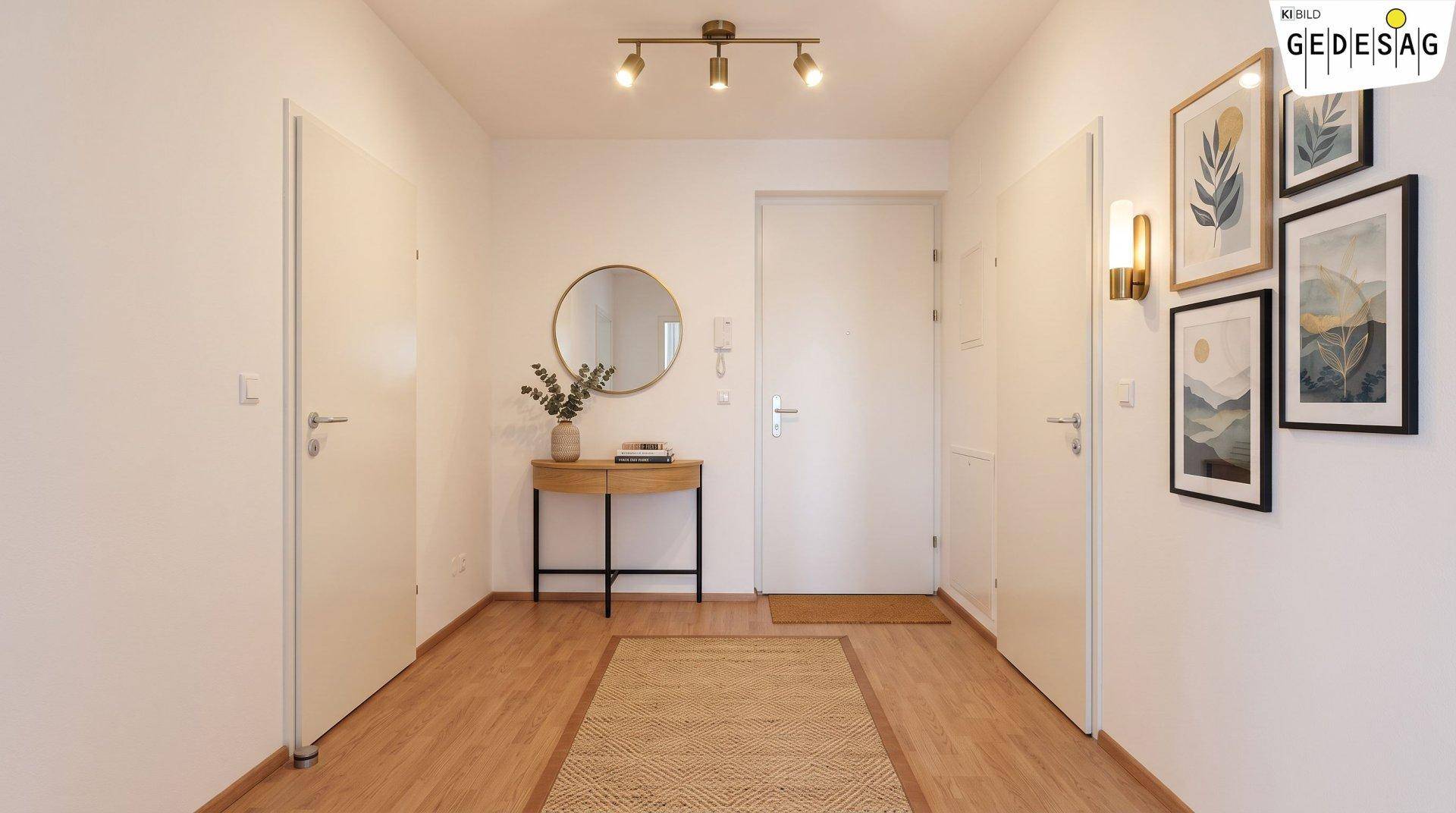 Heller Eingangsbereich mit Holzboden, Spiegel, Konsole und dekorativen Bildern an der Wand.
