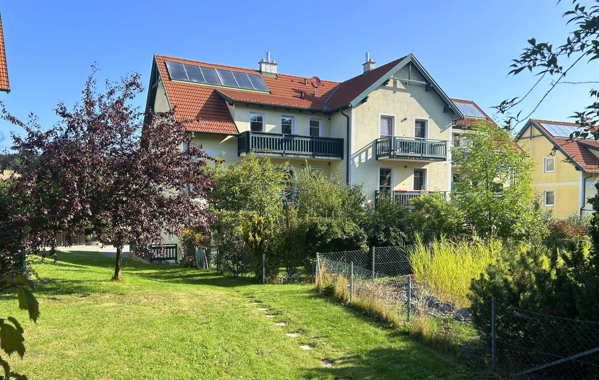 Ansicht des Hauses mit Photovoltaikanlage und einem gepflegten Rasenbereich im Garten.