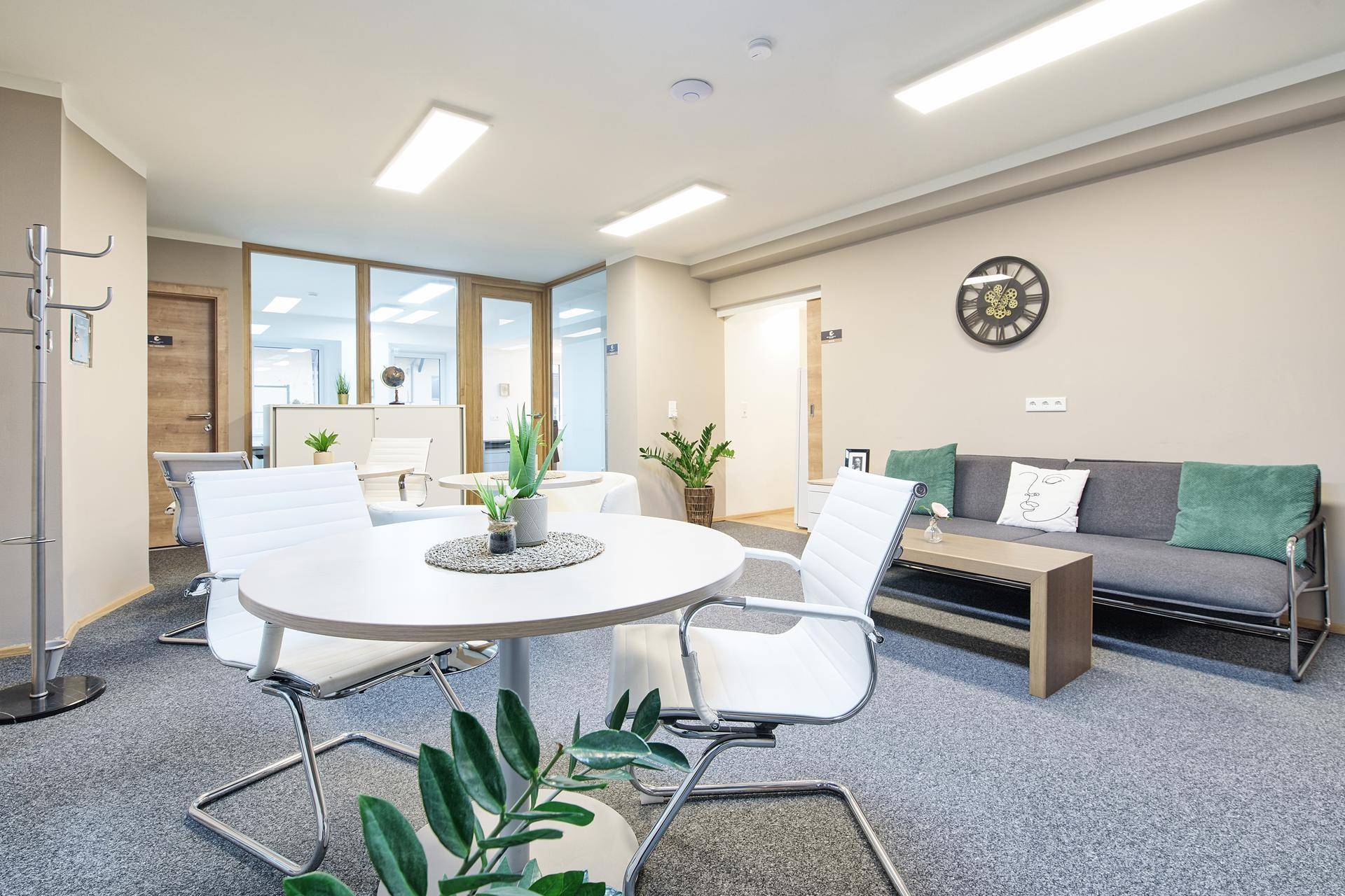 Gemütlicher Loungebereich mit rundem Tisch, bequemen Stühlen und Sofa, ideal für informelle Treffen.