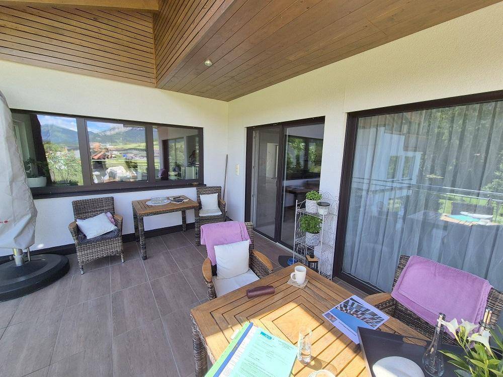 Geräumige Terrasse mit Holzdach und bequemen Möbeln, ideal zum Entspannen mit Aussicht.
