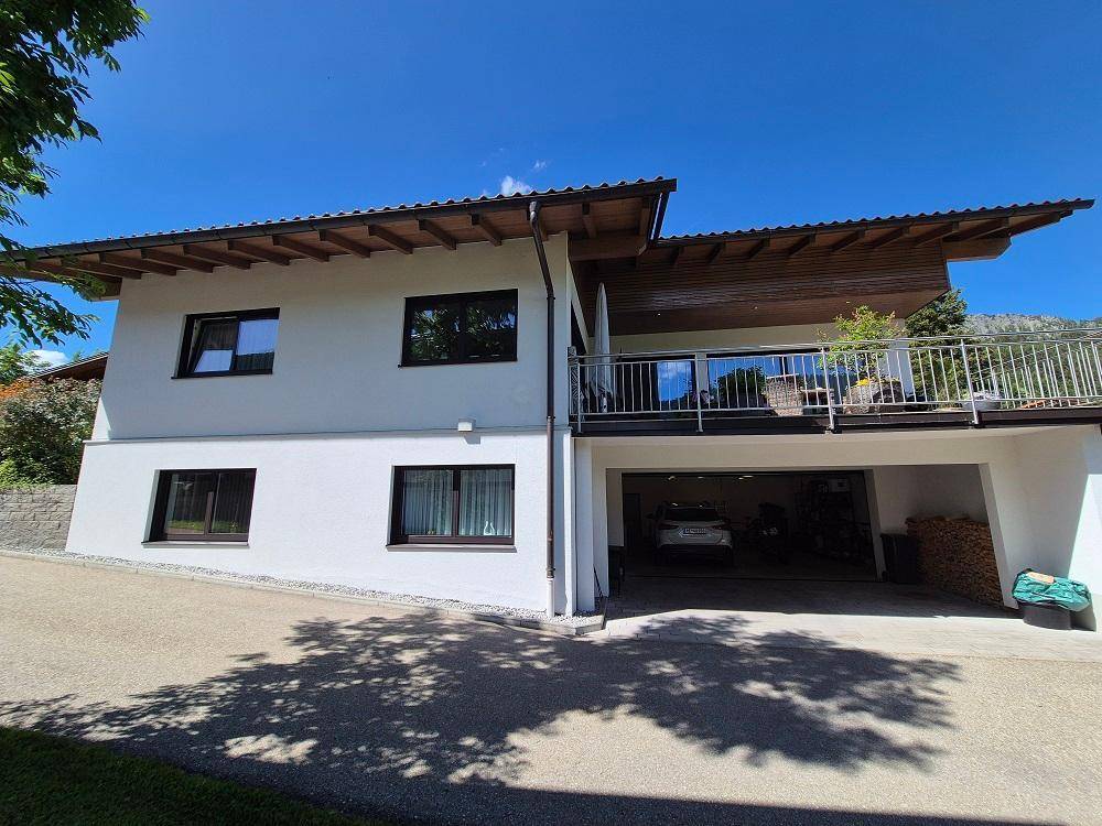 Rückansicht des Hauses mit großem Balkon, Garage und moderner Architektur.