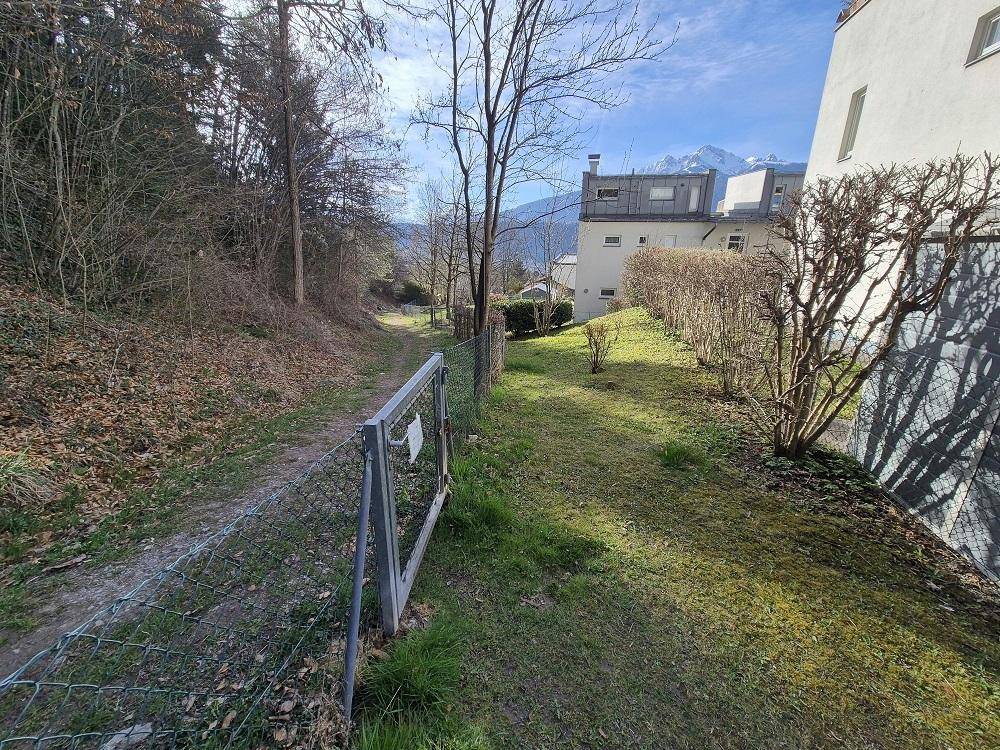 Weg neben dem Gebäude mit Blick auf die umliegende Natur und Berge.