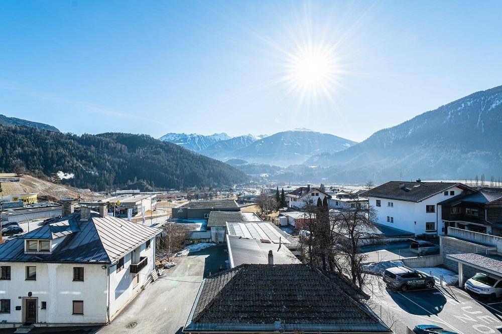 Panoramablick über die Stadt und die umliegenden Berge unter strahlend blauem Himmel.