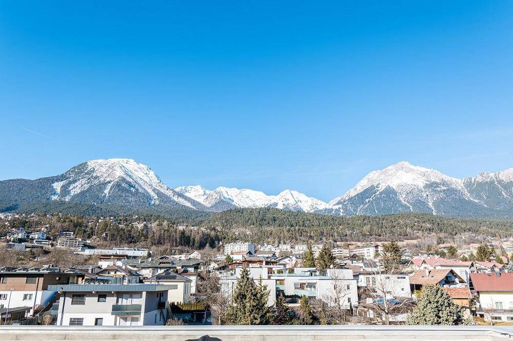 Weitläufiger Panoramablick auf die schneebedeckten Berge und die umliegende Siedlung.
