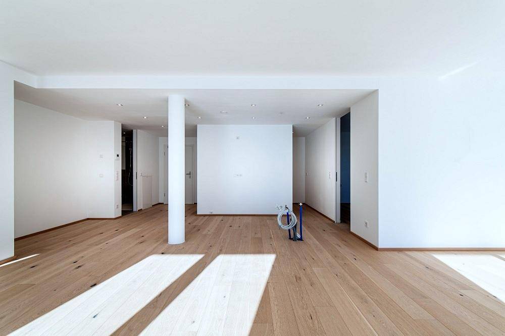 Geräumiger Innenraum mit hellem Eichenparkett und weiß gestrichenen Wänden, bereit für die Einrichtung.