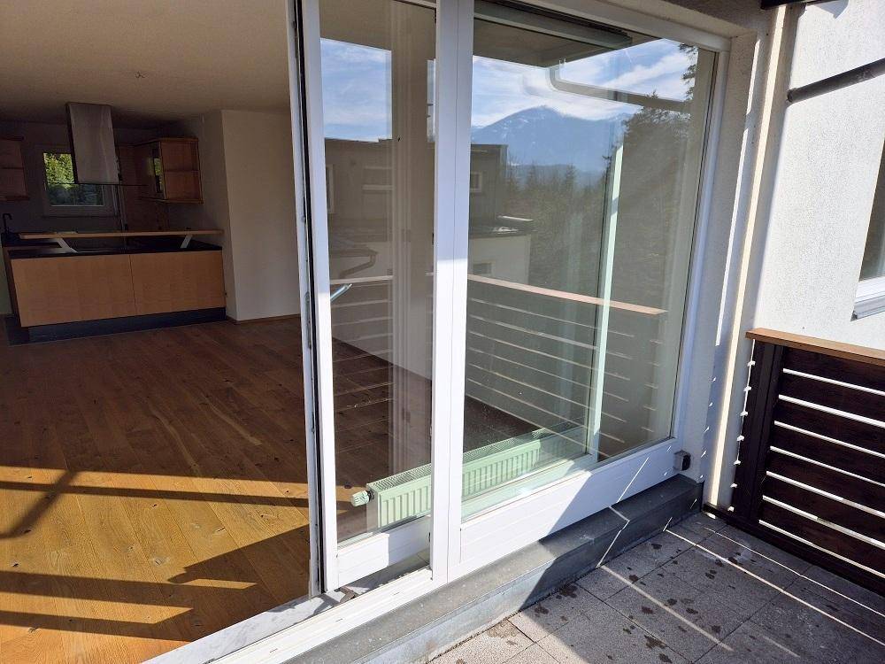 Zugang zum Balkon durch große Glasschiebetüren, die viel Licht in den Innenraum lassen.