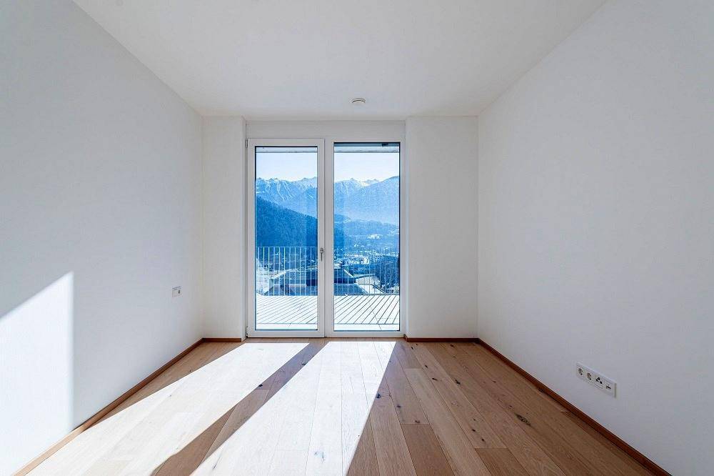Schlafzimmer mit großen Fenstern, die einen weiten Blick auf die schneebedeckten Berge bieten.