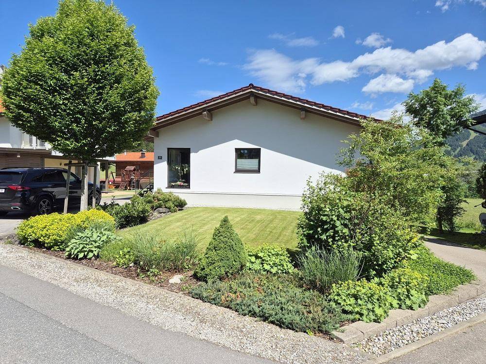 Gepflegter Vorgarten mit Rasenfläche und vielfältiger Bepflanzung vor dem modernen Einfamilienhaus.