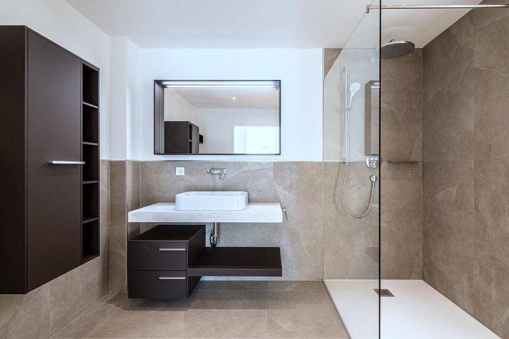 Stilvolles Badezimmer mit großformatigen Fliesen, modernem Waschtisch und begehbarer Dusche.