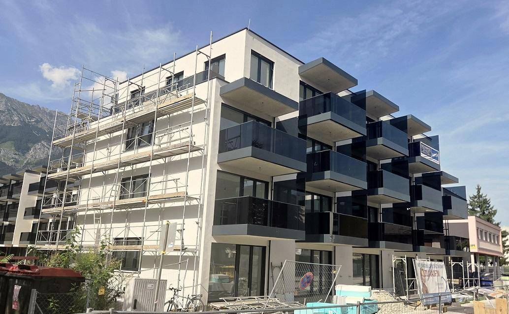 Neubauwohngebäude mit moderner Architektur und gestaffelten Balkonen während der Bauphase.