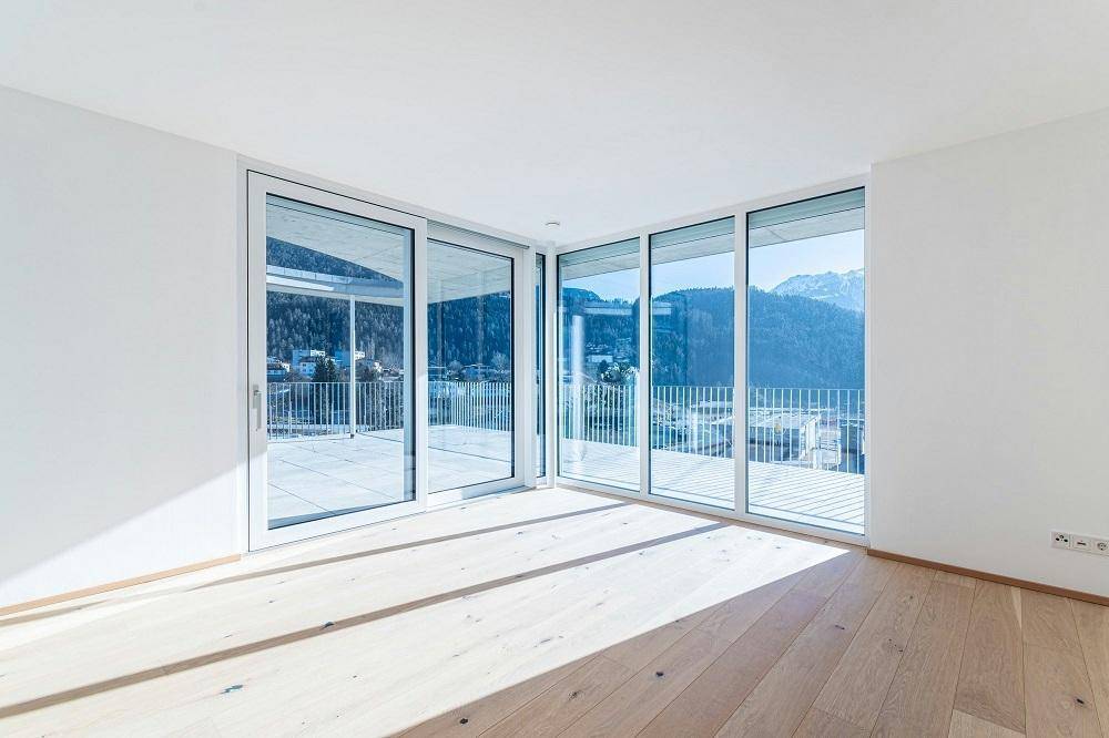 Heller Wohnraum mit Eichenparkett und bodentiefen Fenstern mit Zugang zur Terrasse.