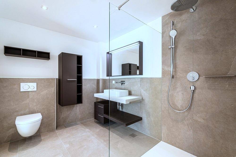 Modernes Badezimmer mit begehbarer Dusche, Wand-WC und eleganten Fliesen in Erdtönen.